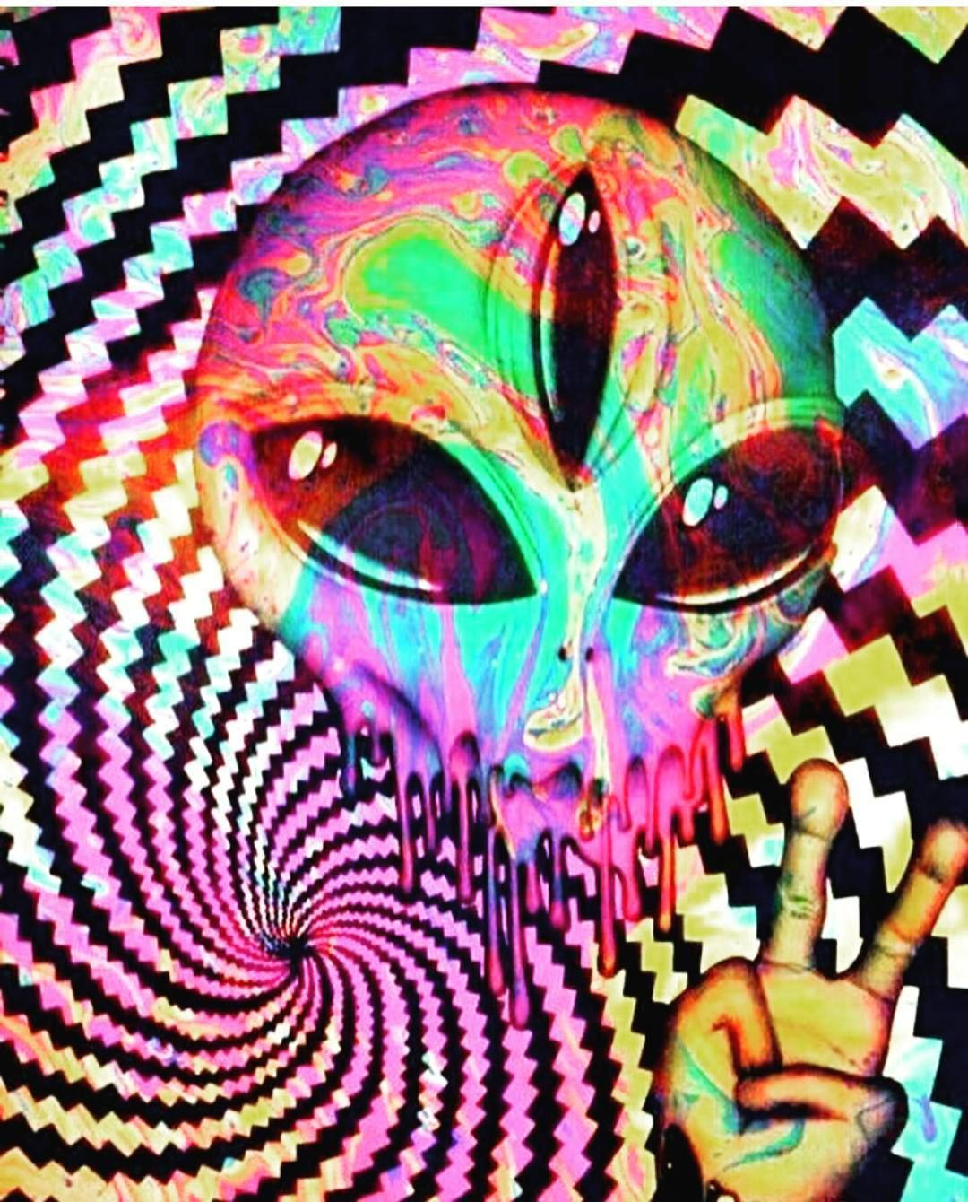 迷幻美學 桌布 壁紙 — 一個擁有彩虹皮膚和大眼睛的迷幻外星人，從旋轉的鋸齒狀漩渦中凝視，同時做出和平手勢。