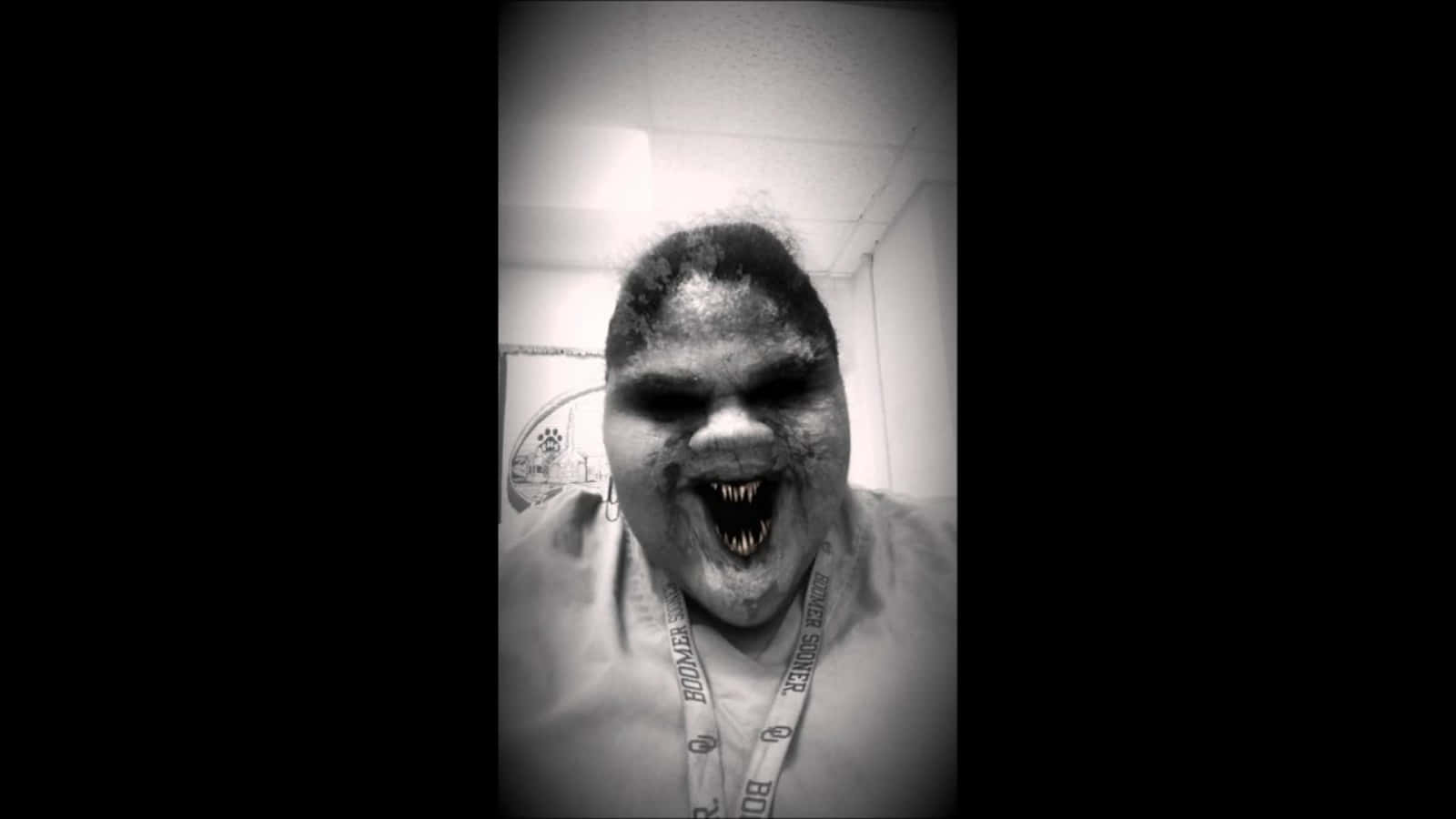 Scary Face 桌布 壁紙 — 一個擁有怪異喪屍般面孔和尖銳牙齒的人，在一張黑白自拍照中露出威脅性的笑容。