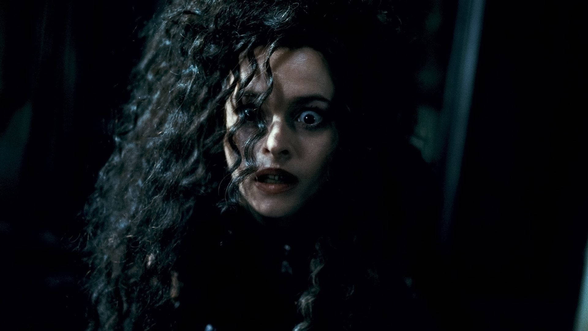 Bellatrix 桌布 壁紙 — 一個擁有狂野深色捲髮的女人在昏暗燈光下，睜大眼睛、嘴唇微張，震驚地凝視著。