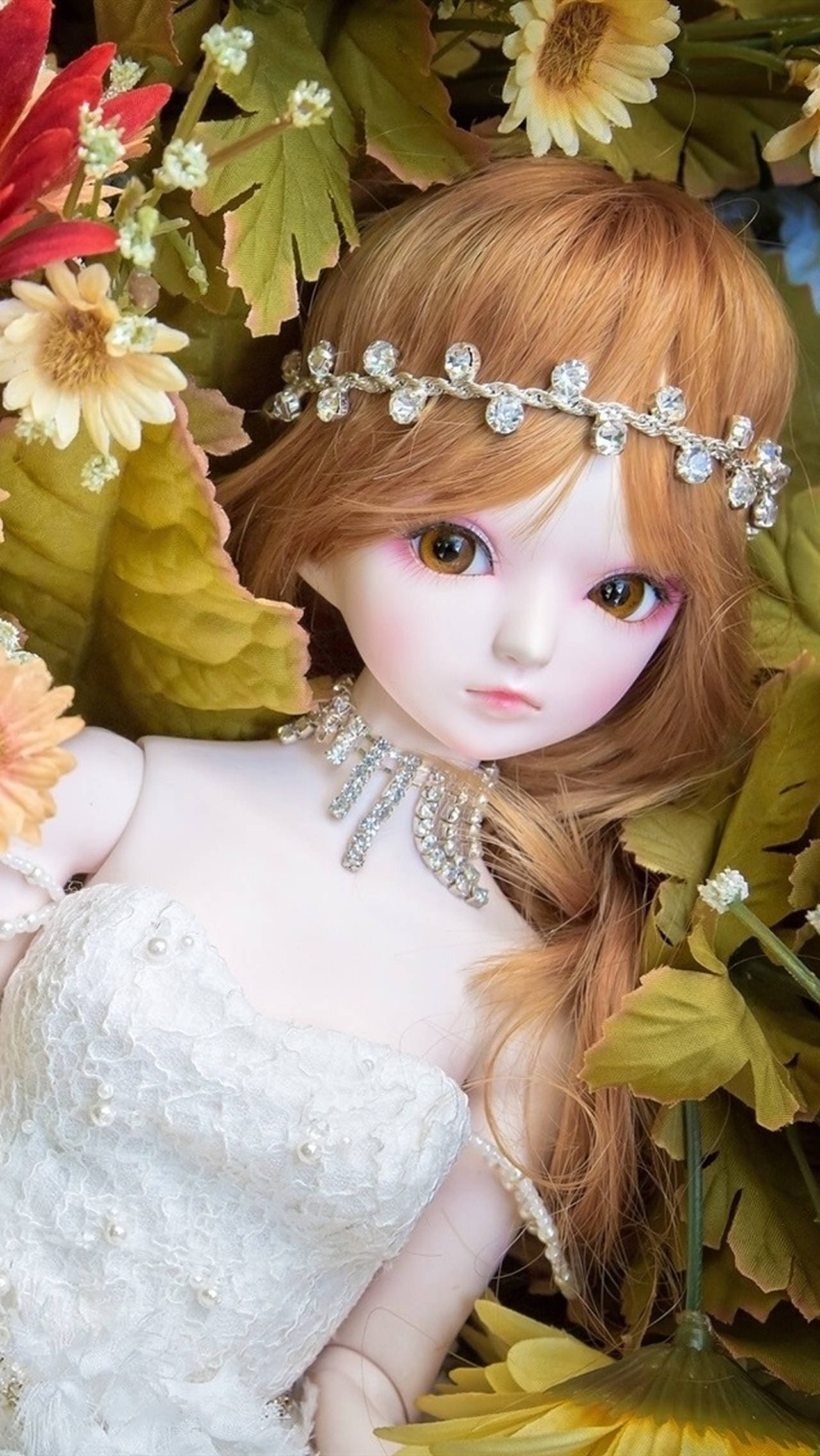 Doll 桌布 壁紙 — 一個擁有琥珀色眼睛和鑲有寶石頭帶的洋娃娃，在鮮豔的花朵和茂密的綠葉中休息。