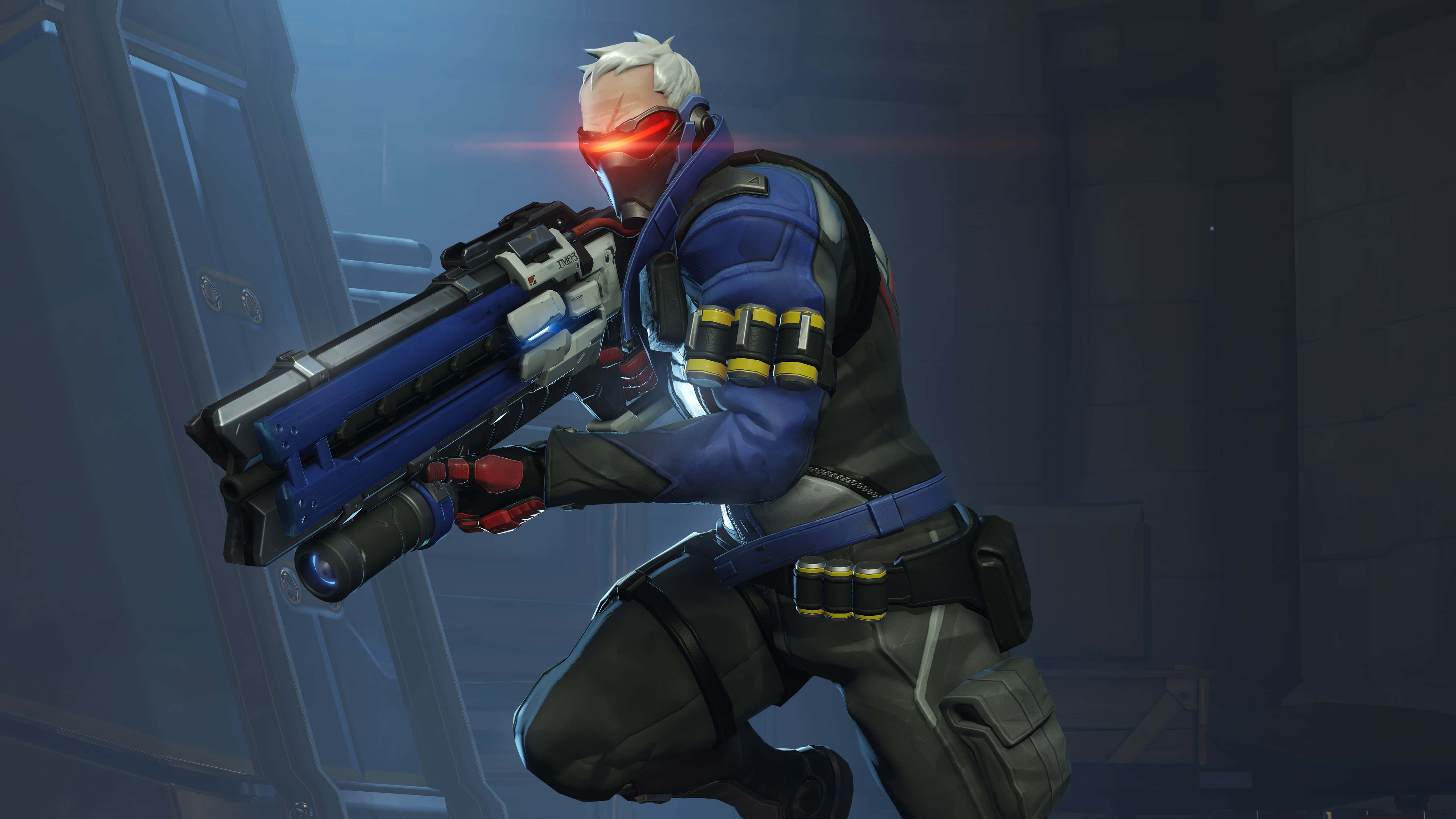Soldier 76 桌布 壁紙 — 一個擁有發光紅眼和大型藍色武器的未來士兵，蹲在昏暗的工業環境中。