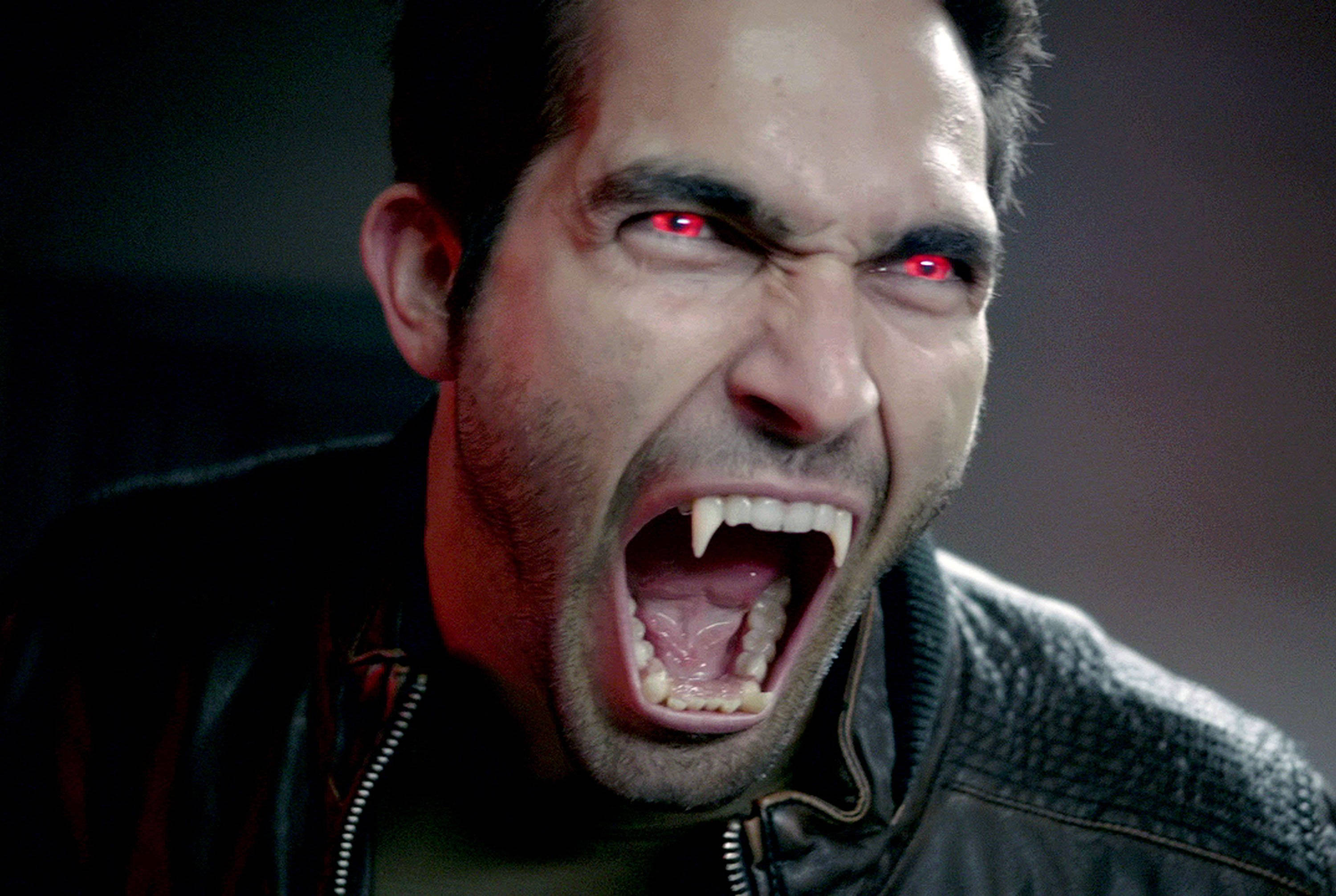 scott mccall 桌布 壁紙 — 一個擁有發光紅眼和尖牙的吸血鬼在黑暗特寫中兇猛咆哮。