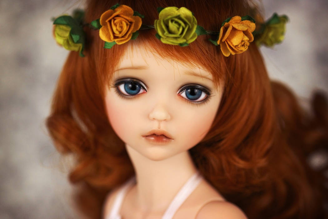 Dolls 桌布 壁紙 — 一個擁有藍色大眼睛和紅色頭髮的洋娃娃，戴著黃綠相間的玫瑰花冠的特寫。