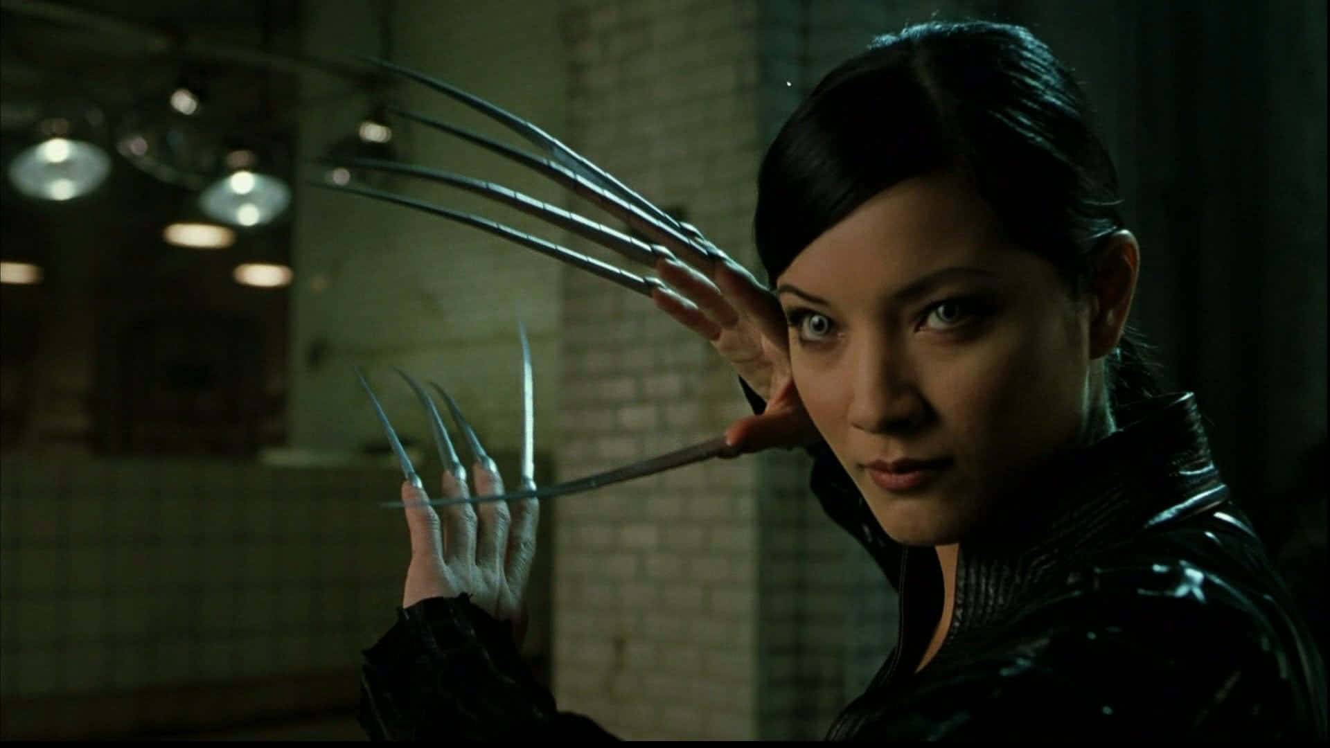 Lady Deathstrike 桌布 壁紙 — 一個擁有金屬爪的女人在一個光線昏暗的磁磚房間裡，懸掛著燈飾，伸出雙手。