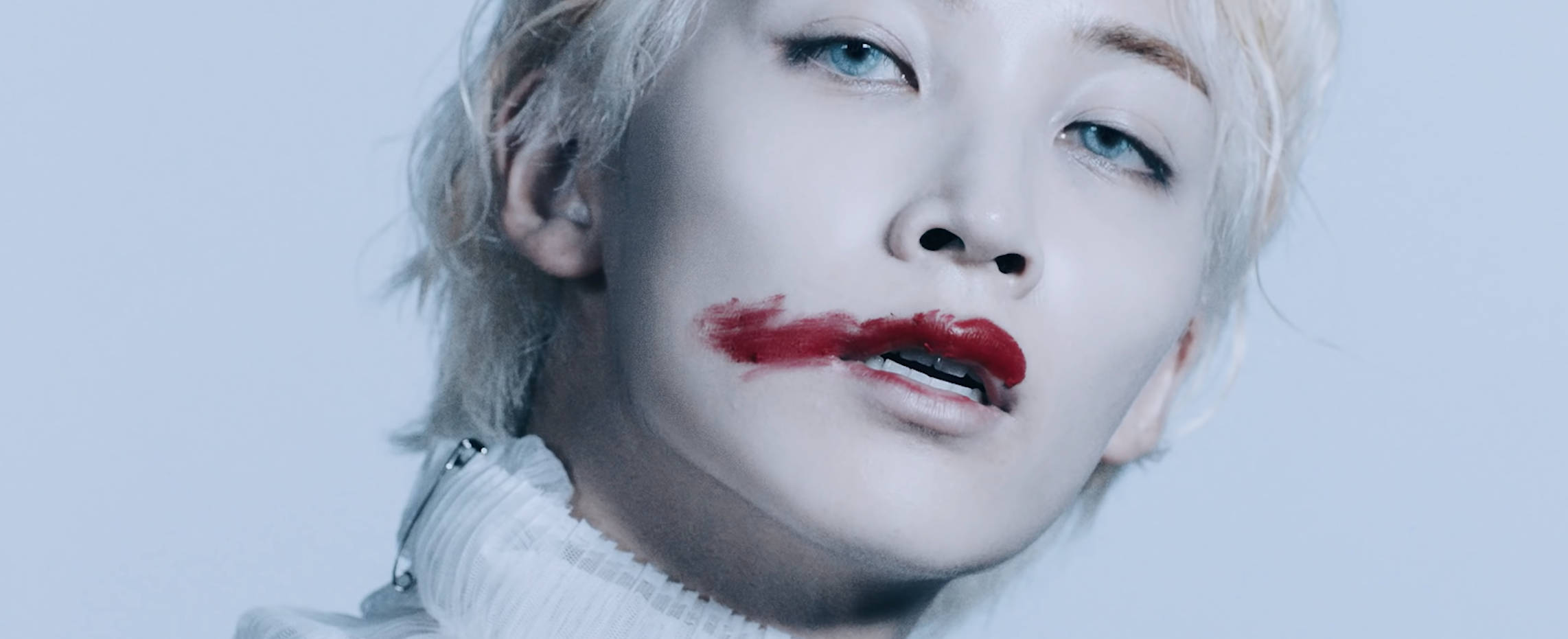 yoon jeonghan 桌布 壁紙 — 一個擁有鉑金色頭髮和鮮豔紅唇的人，在淡藍色背景下強烈凝視。