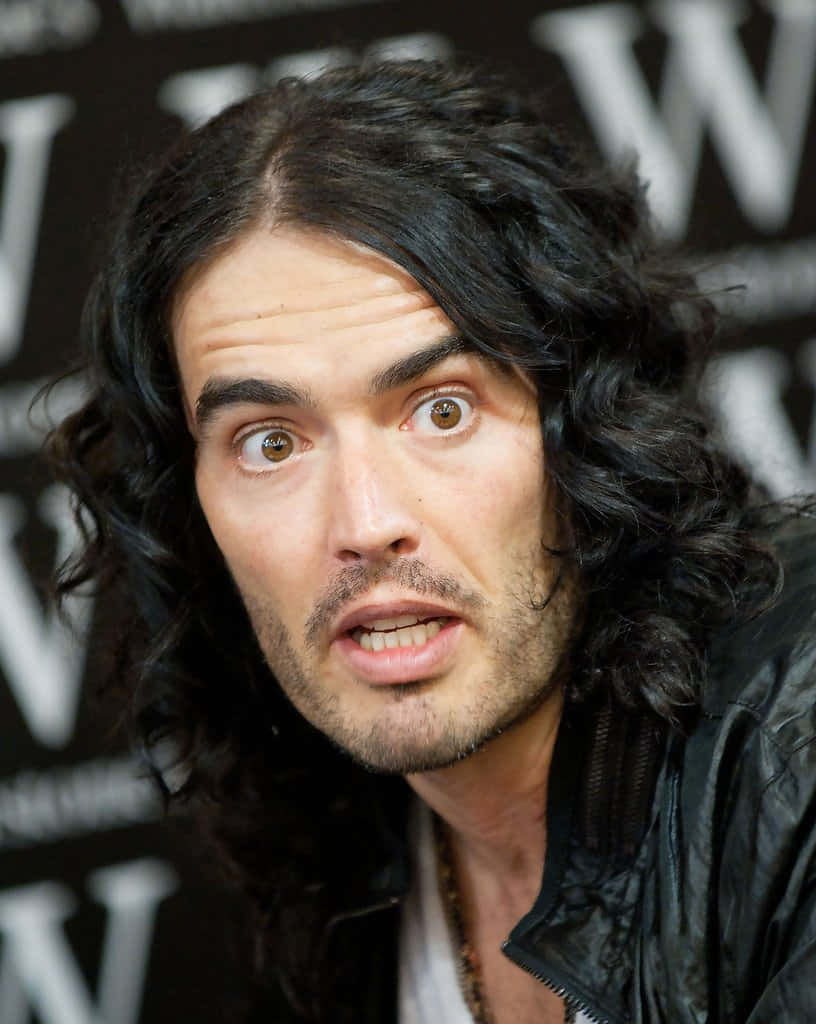 Celebrity 桌布 壁紙 — 一個擁有長深色捲髮和大眼睛的男人，在模糊的黑白背景前震驚地凝視。