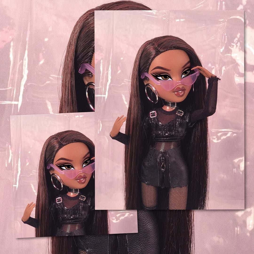 Bratz 桌布 壁紙 — 一個擁有長長棕色頭髮和粉紅色太陽眼鏡的 Bratz 公仔，穿著黑色網狀服裝，在粉紅色塑膠背景前擺姿勢。