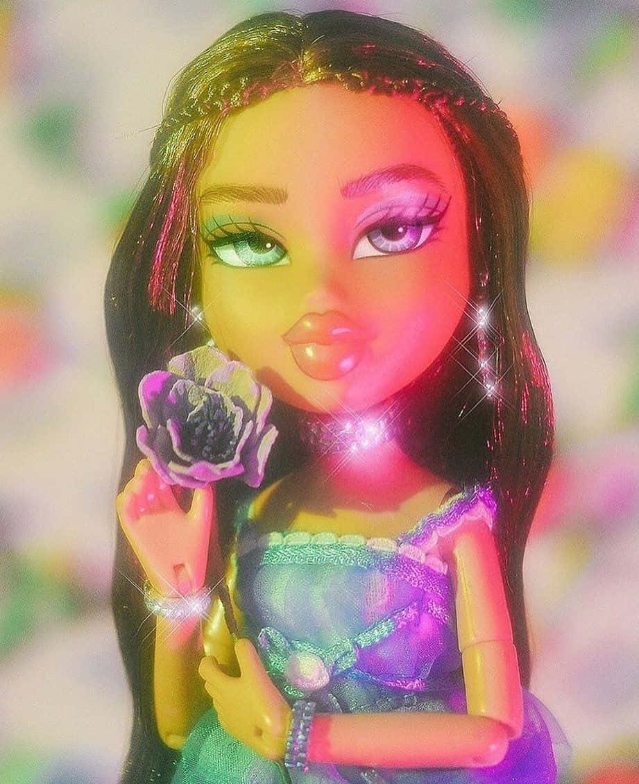 Bratz 桌布 壁紙 — 一個擁有長長黑髮和閃亮化妝的娃娃，在色彩繽紛的模糊背景前拿著一朵紫色花。