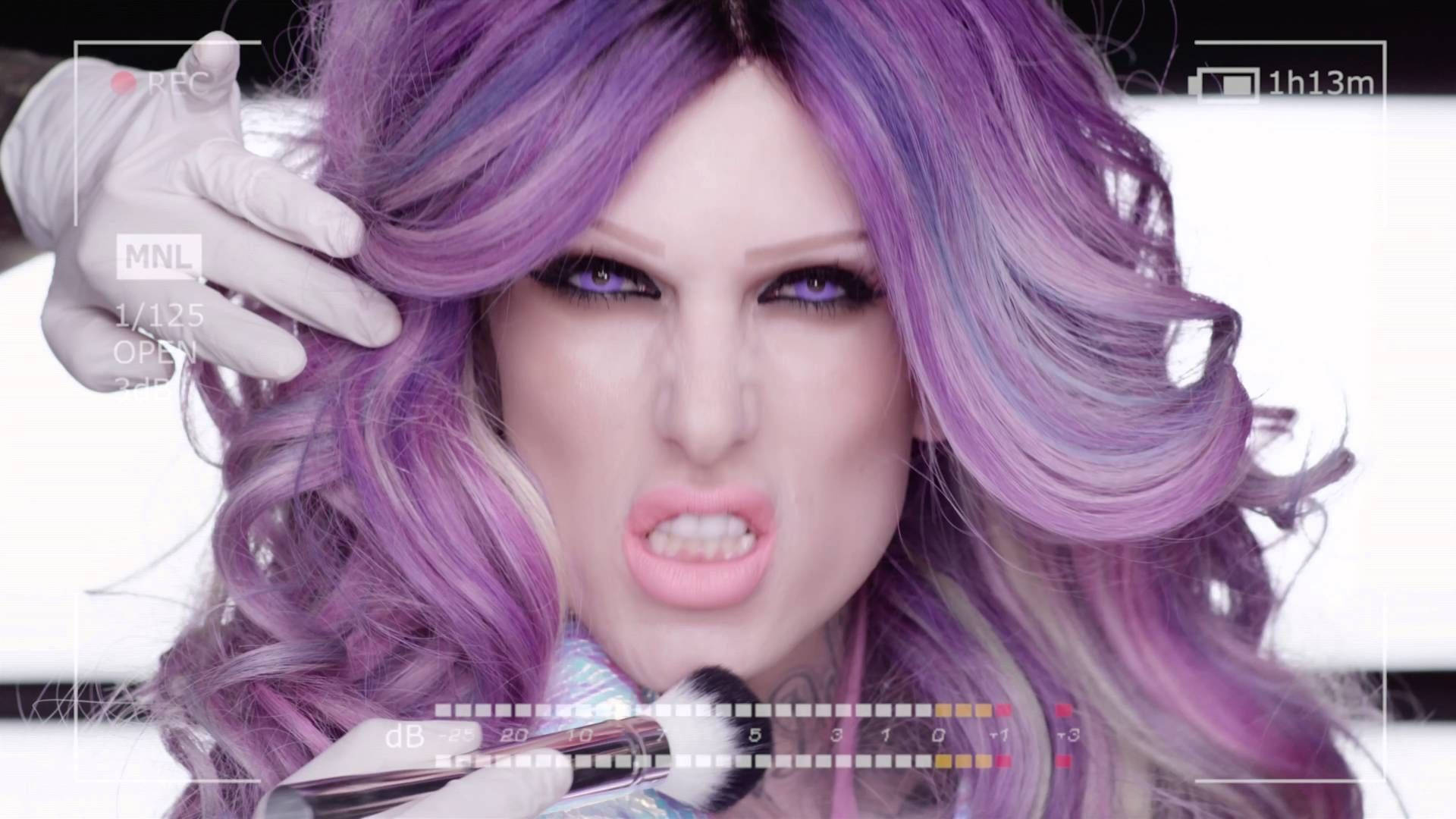 Jeffree Star 桌布 壁紙 — 一個擁有鮮豔紫色頭髮和戲劇化妝容的人，戴著白色手套拿著麥克風，周圍是相機界面疊加層。