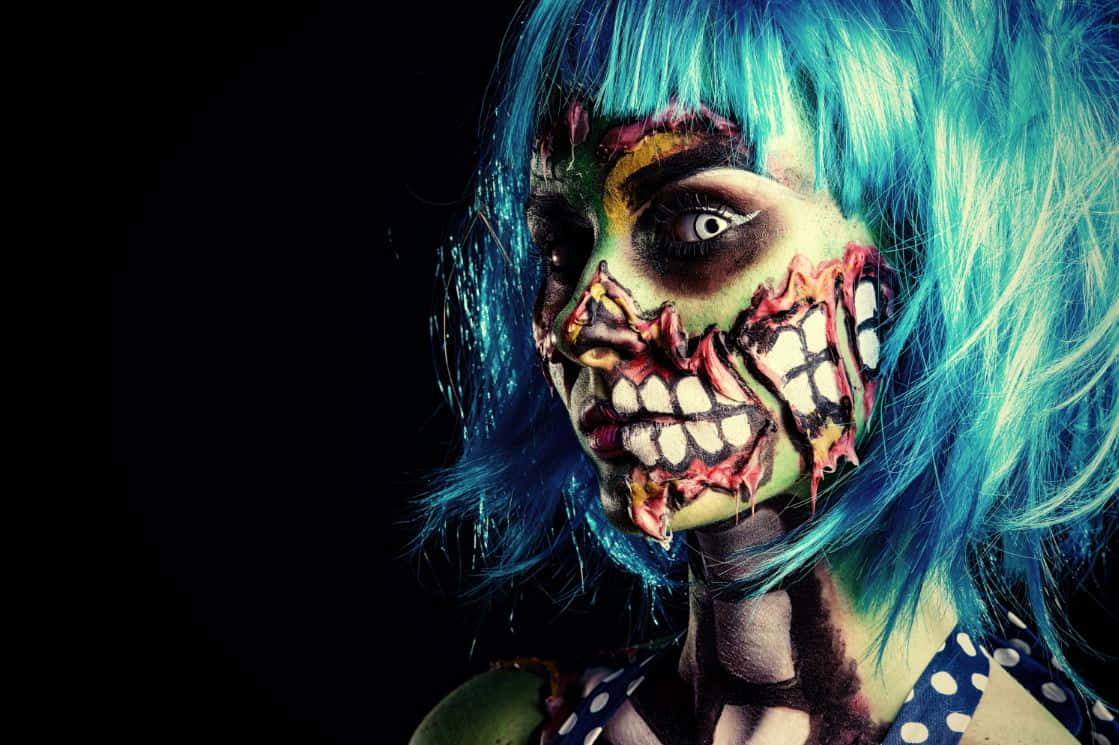 Halloween Makeup 桌布 壁紙 — 一個擁有鮮豔藍色頭髮和恐怖殭屍妝容的人，在黑色背景下強烈凝視。