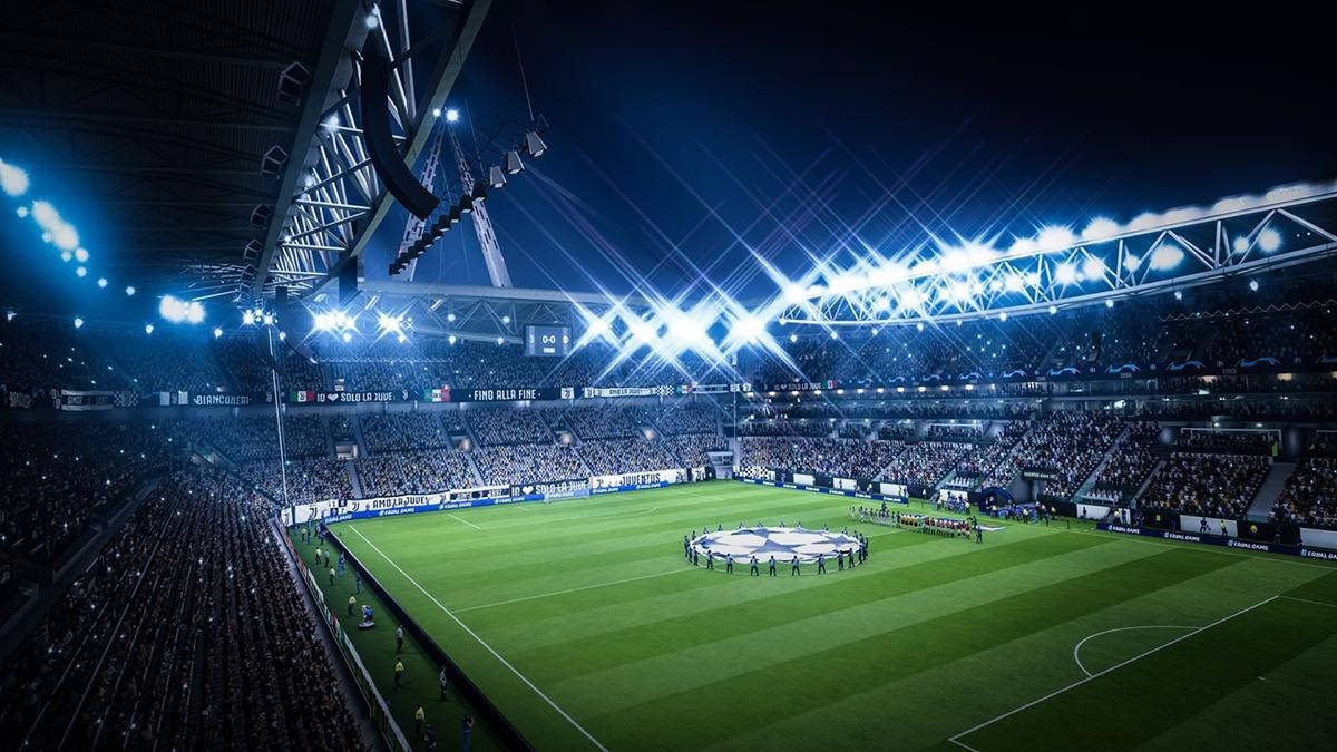 Uefa 桌布 壁紙 — 一個擠滿觀眾的夜間足球場，被明亮的聚光燈照亮，球員在比賽前繞場一周。
