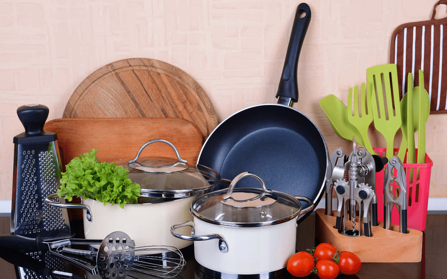 1440p Kitchen 桌布 壁紙 — 一個整齊排列的廚房場景，包括鍋、平底鍋、用具和新鮮蔬菜，背景是瓷磚牆。
