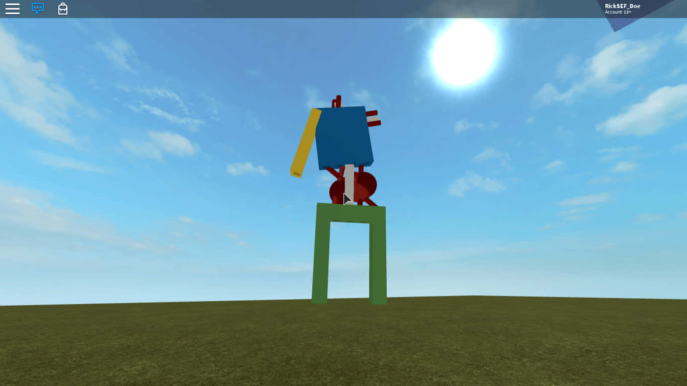 Roblox Noob 桌布 壁紙 — 一個方塊狀的藍色和紅色機器人站在綠色基座上，在簡約的草地上，頭頂明亮的太陽。