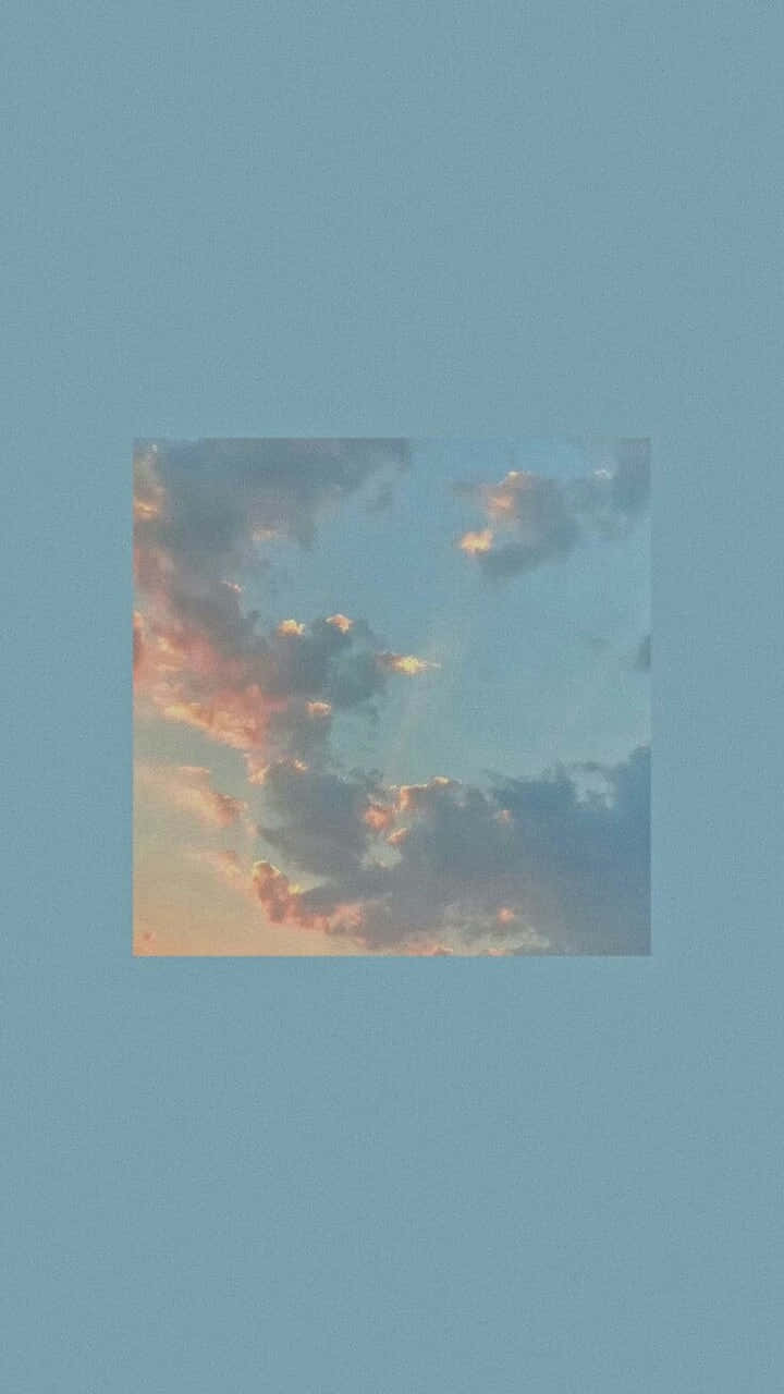 Cloud Aesthetic 桌布 壁紙 — 一個方形嵌入的柔和粉紅和橙色雲朵，襯托著柔和的藍天，並由純藍色背景框住。