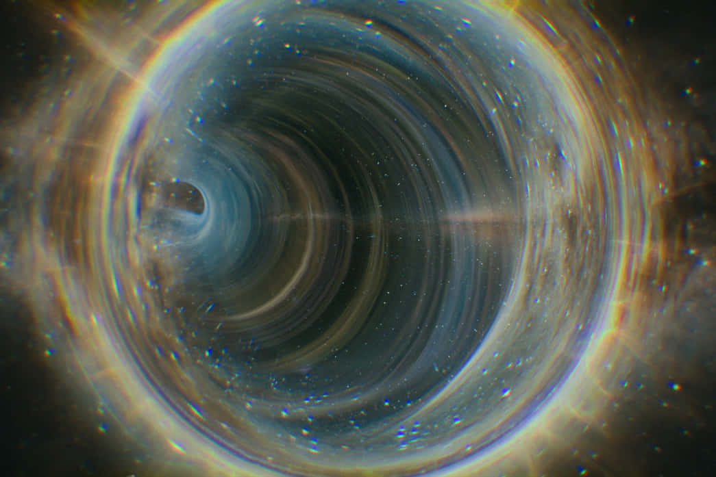 Time Travel 桌布 壁紙 — 一個旋轉的宇宙漩渦，帶有發光的吸積盤和圍繞黑洞的星光條紋。