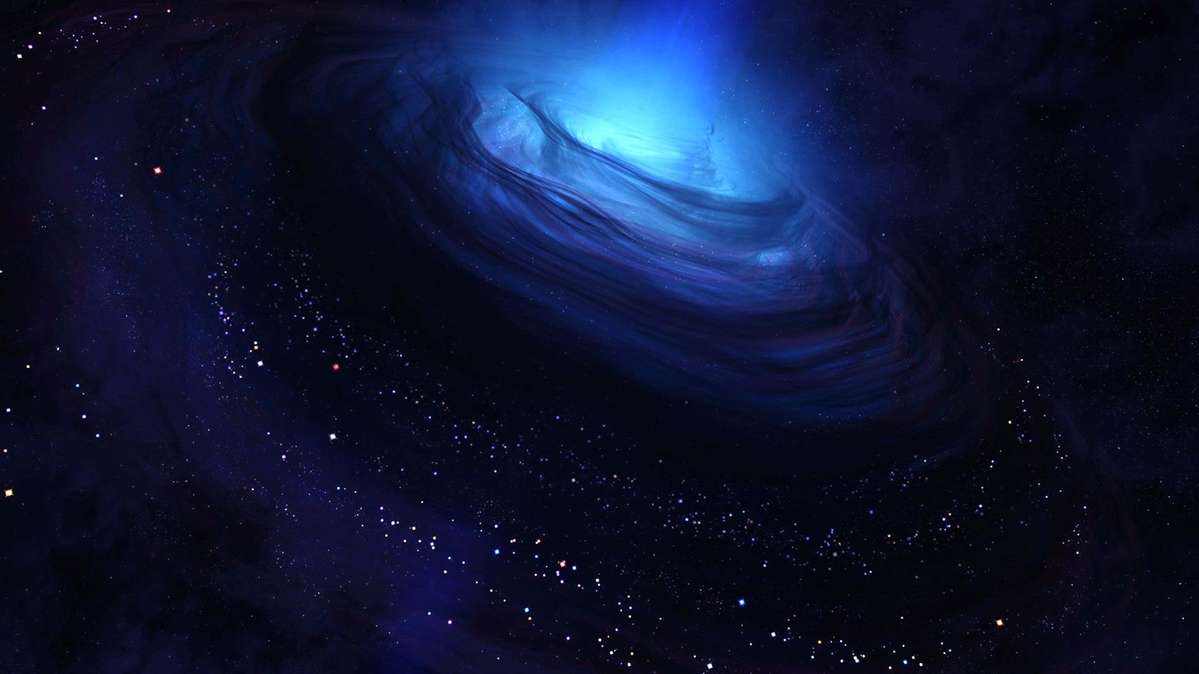 宇宙 桌布 壁紙 — 一個旋轉的藍色螺旋星系在深空的星場中發出宇宙光芒。