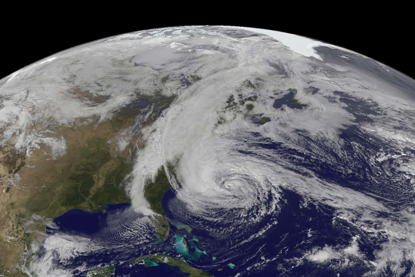 Hurricane 桌布 壁紙 — 一個旋轉的颶風主導了大西洋，從太空看到地球彎曲的地平線和下方的雲層圖案。