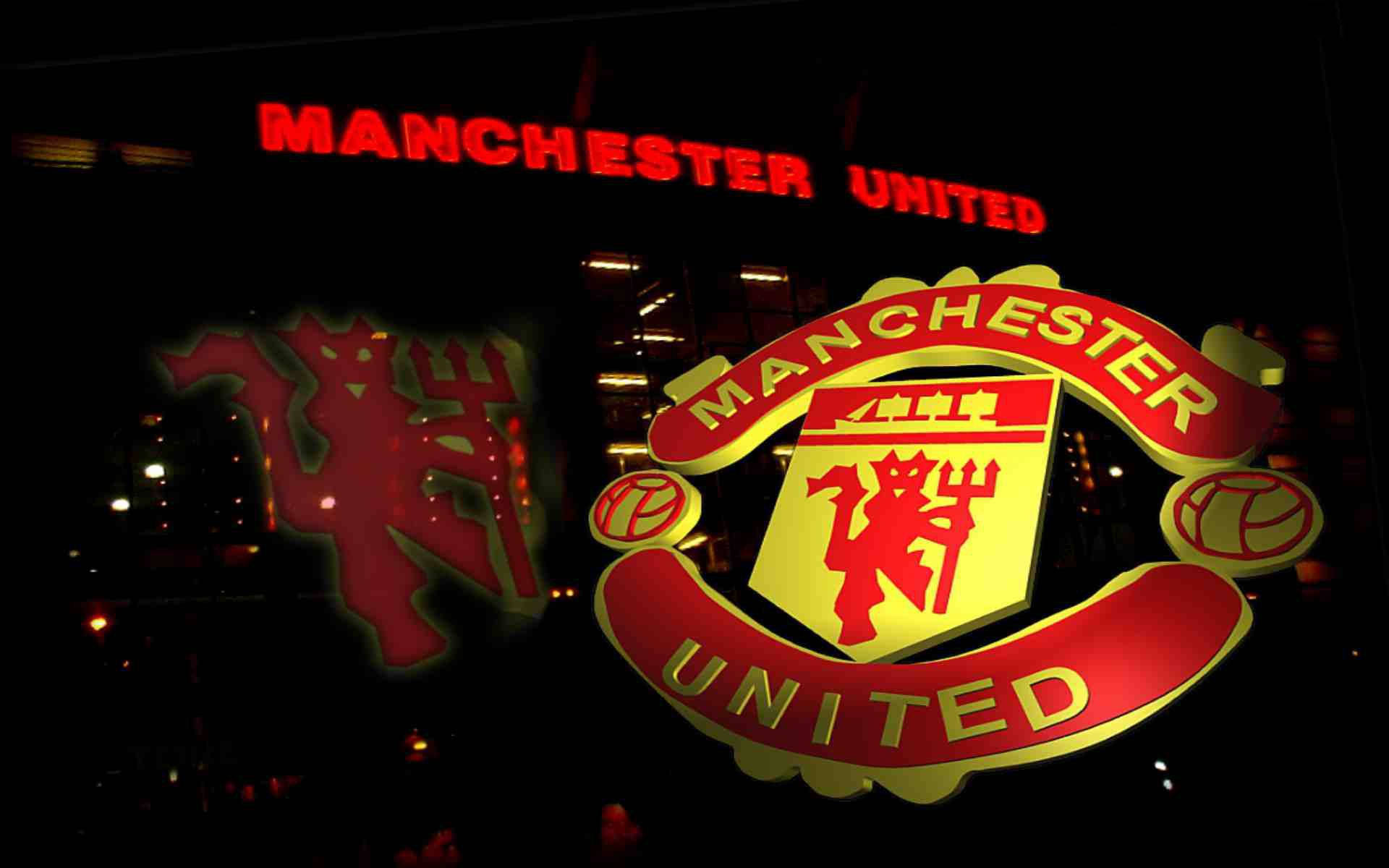 Manchester United Logo 桌布 壁紙 — 一個明亮照明的曼聯標誌和紅色霓虹燈牌在黑暗的城市夜景背景下發光。