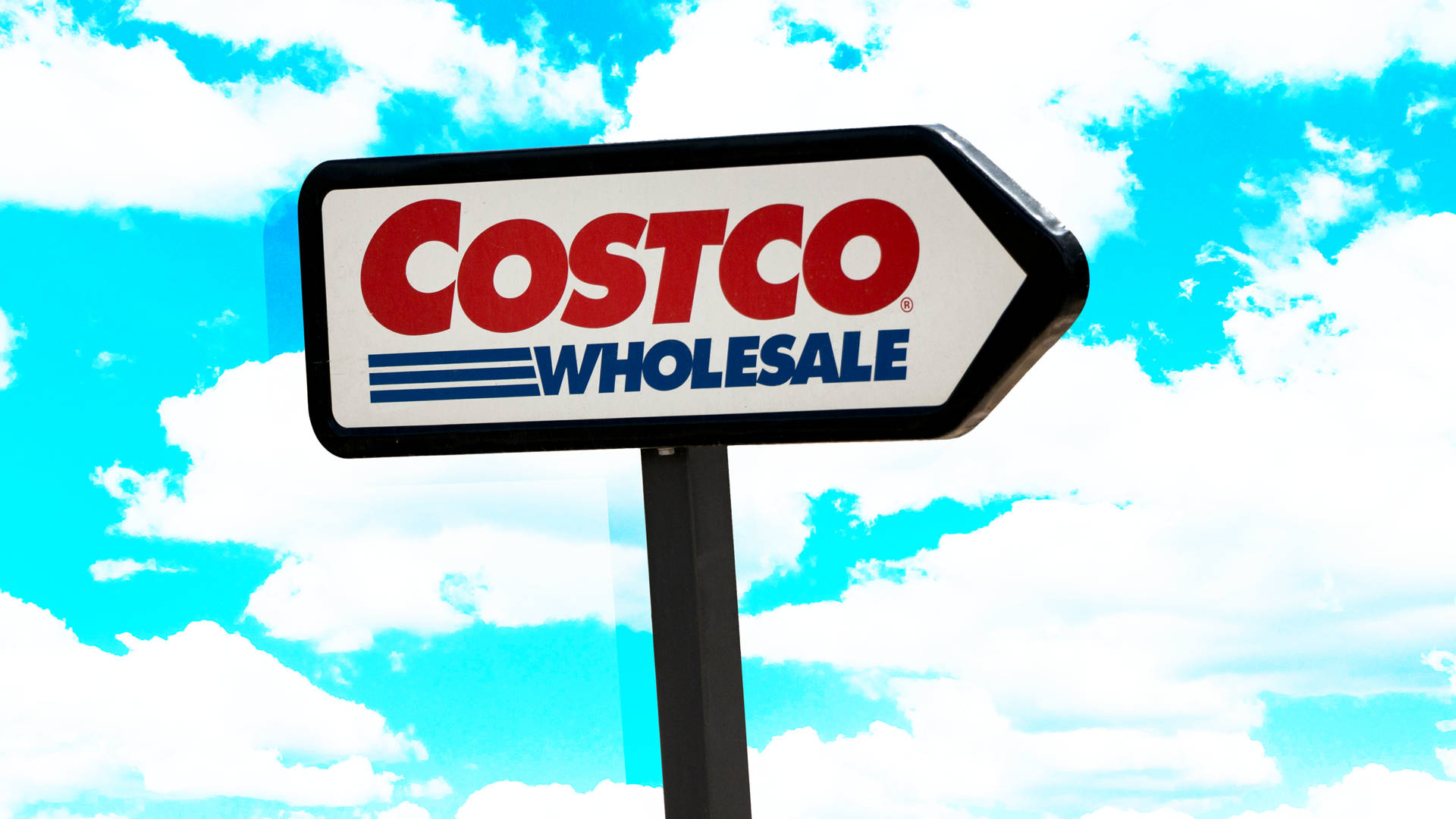 Costco 桌布 壁紙 — 一個明亮的Costco Wholesale箭頭標誌矗立在藍天白雲下。