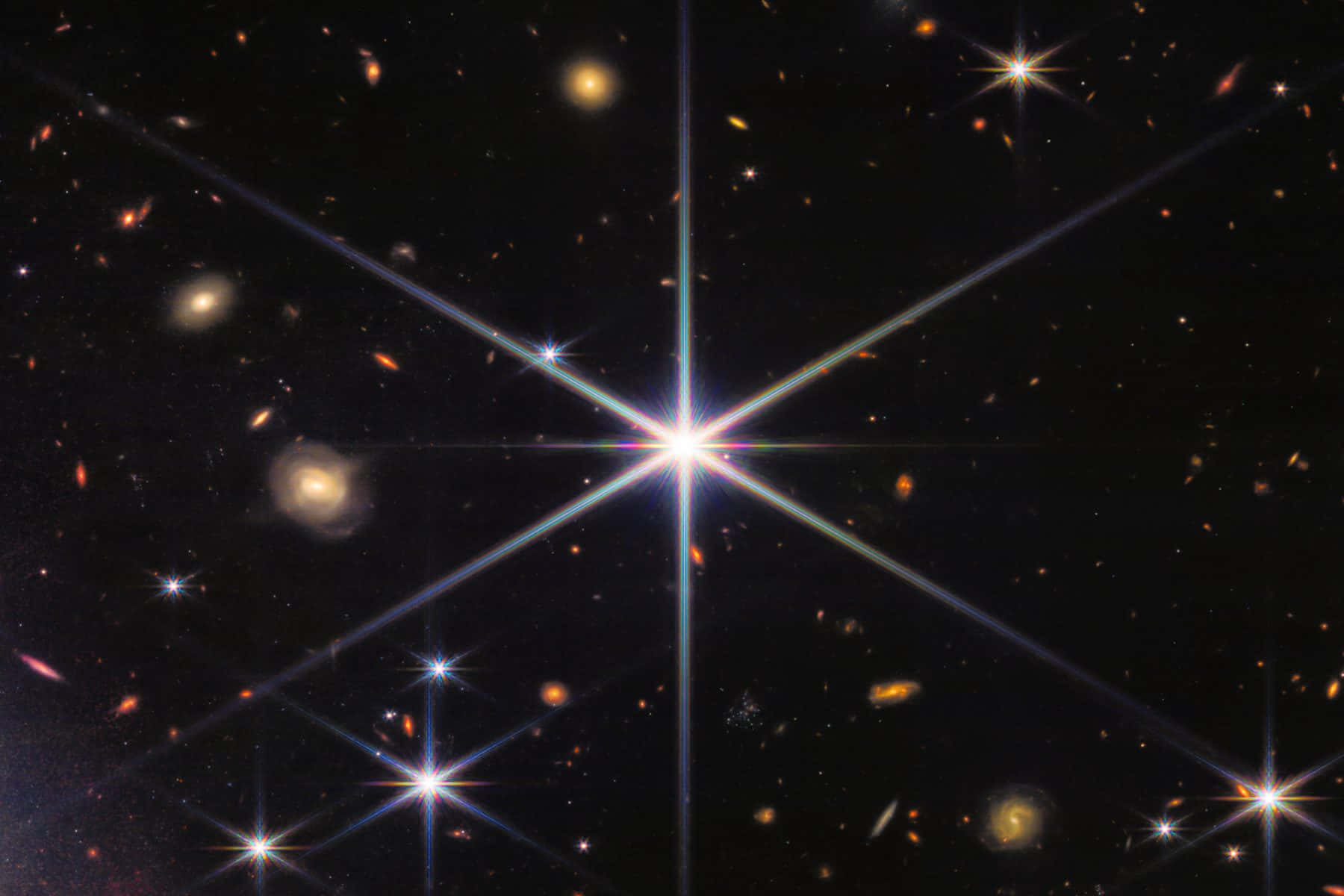 Stars 桌布 壁紙 — 一個明亮的星暴星系在黑暗的宇宙場中散發出強烈的光芒，場中點綴著遙遠的星系和恆星。