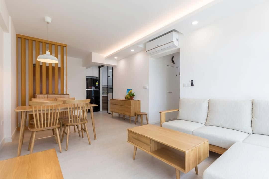 Minimalist Design 桌布 壁紙 — 一個明亮的極簡主義客廳和用餐區，配有淺色木家具和白色牆壁，在溫暖的吊燈下。
