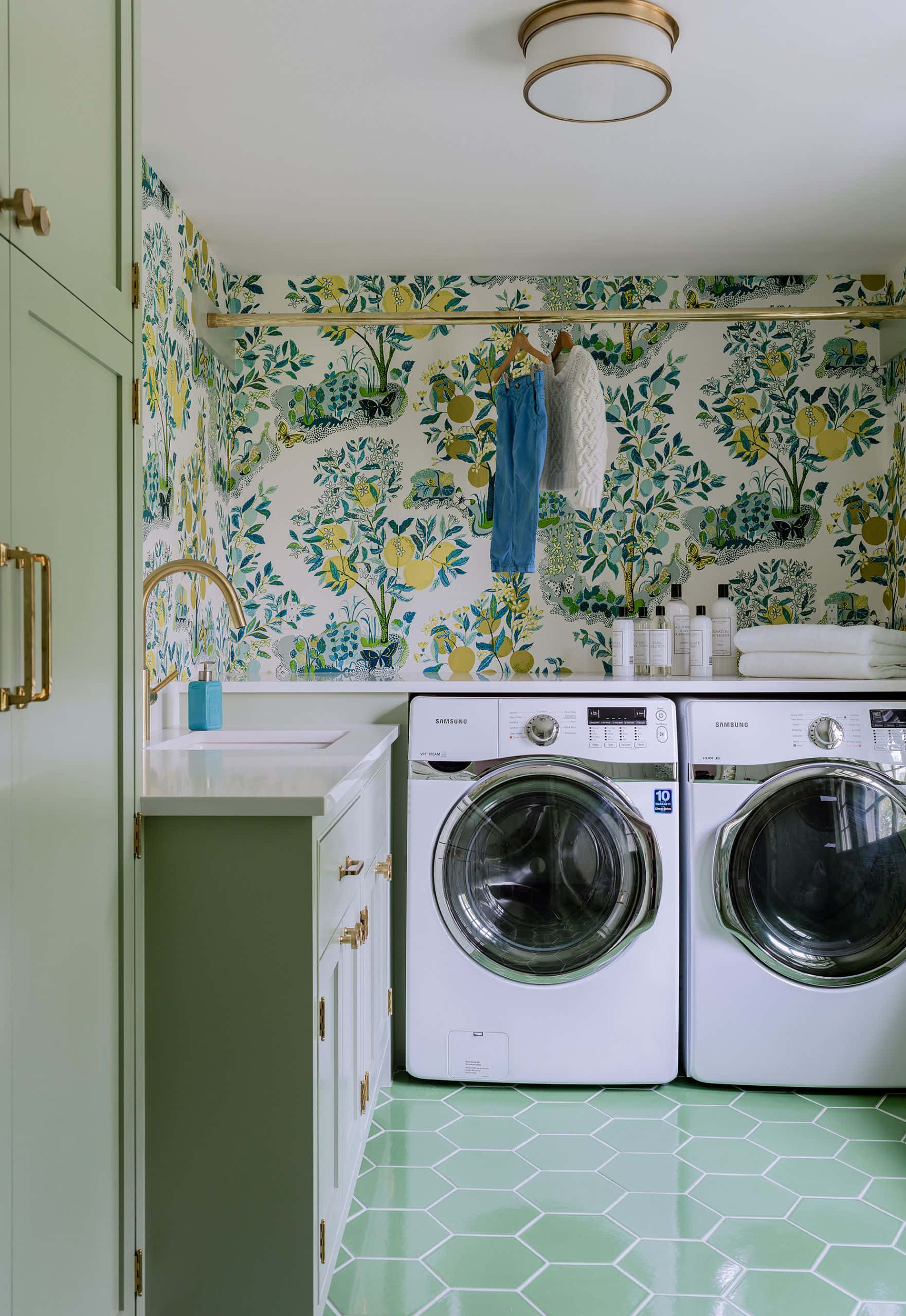 Laundry Room 桌布 壁紙 — 一個明亮的洗衣房，配有綠色六角形地板瓷磚和充滿活力的植物壁紙，上面有檸檬和樹葉。