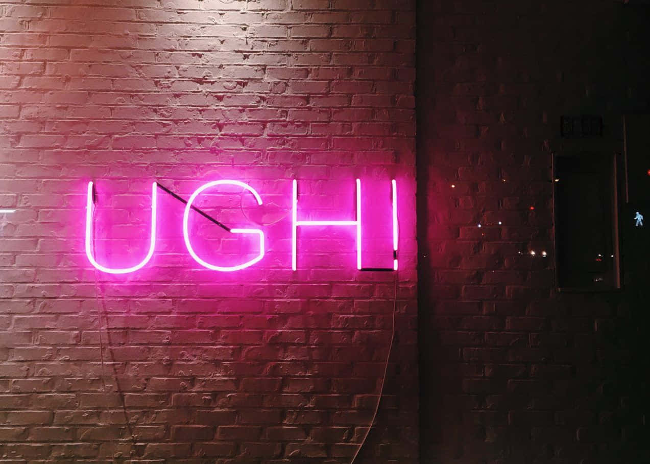 美學 桌布 壁紙 — 一個明亮的粉紅色霓虹燈牌，拼寫出「UGH!」，在昏暗的城市空間中，對著深色磚牆發光。