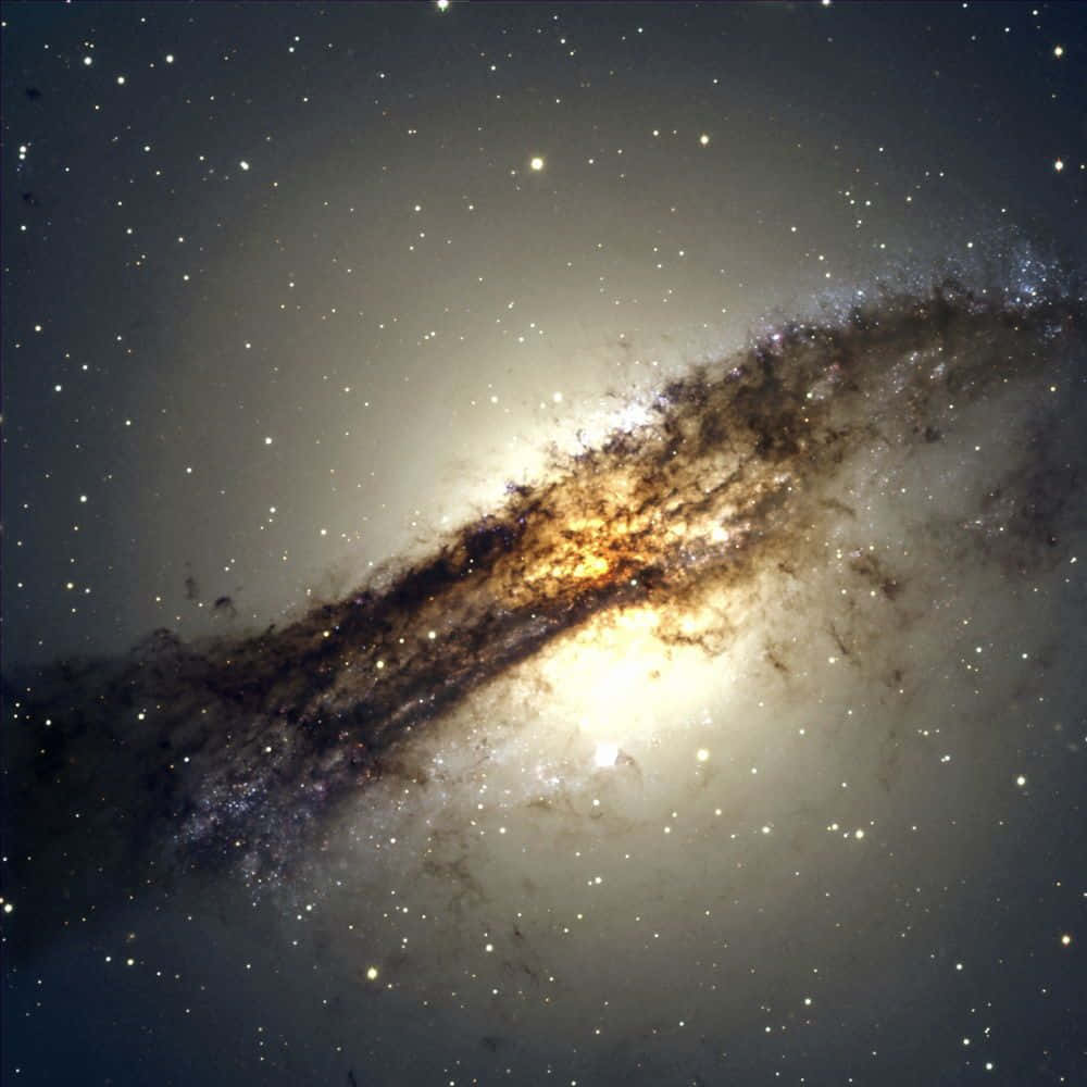 Elliptical Galaxy 桌布 壁紙 — 一個明亮的螺旋星系，帶有發光的核心和黑暗的塵埃帶，對角線延伸穿過星場。