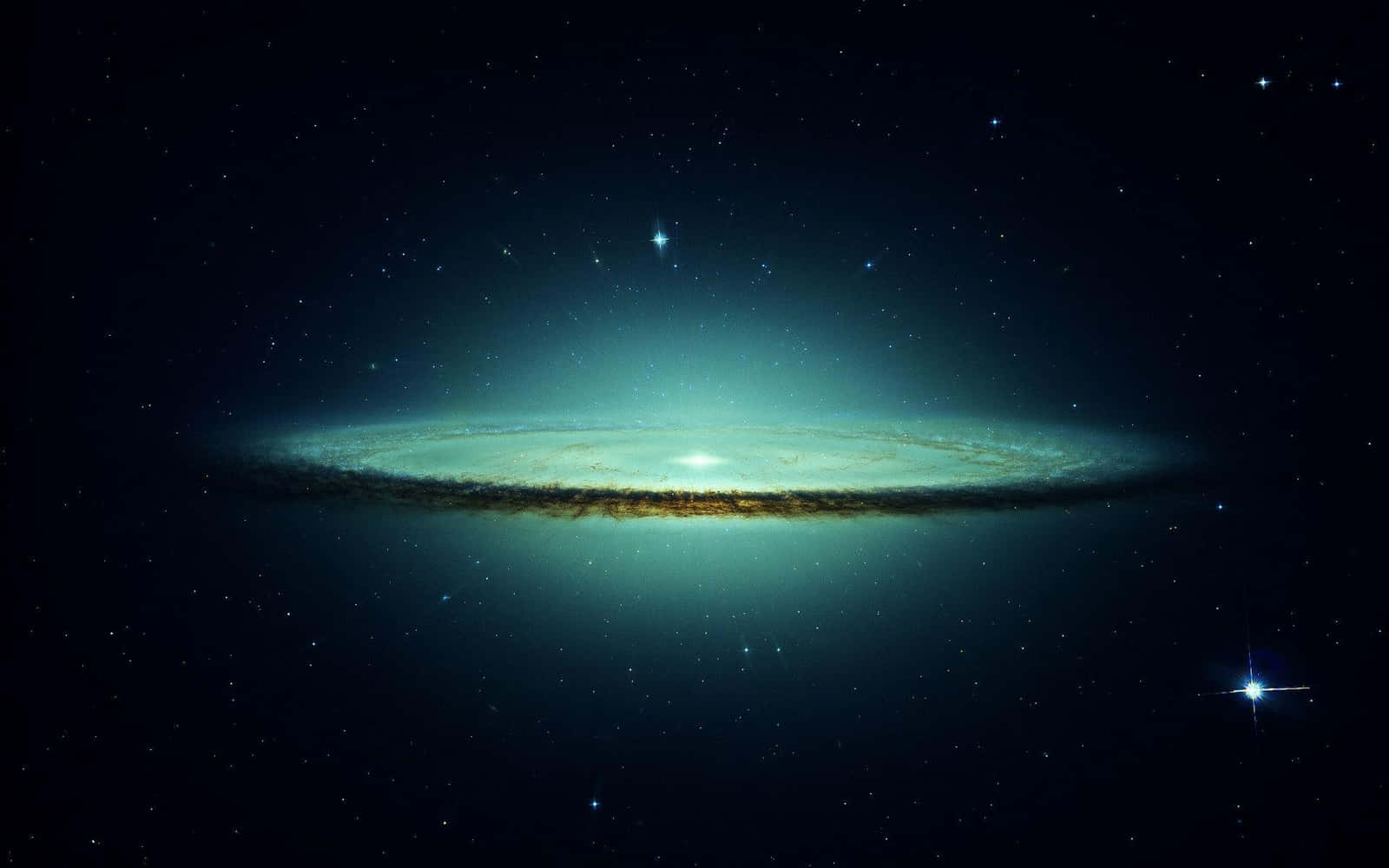 科學 桌布 壁紙 — 一個明亮的螺旋星系在佈滿星星的宇宙虛空中散發出藍綠色和金色的光芒。