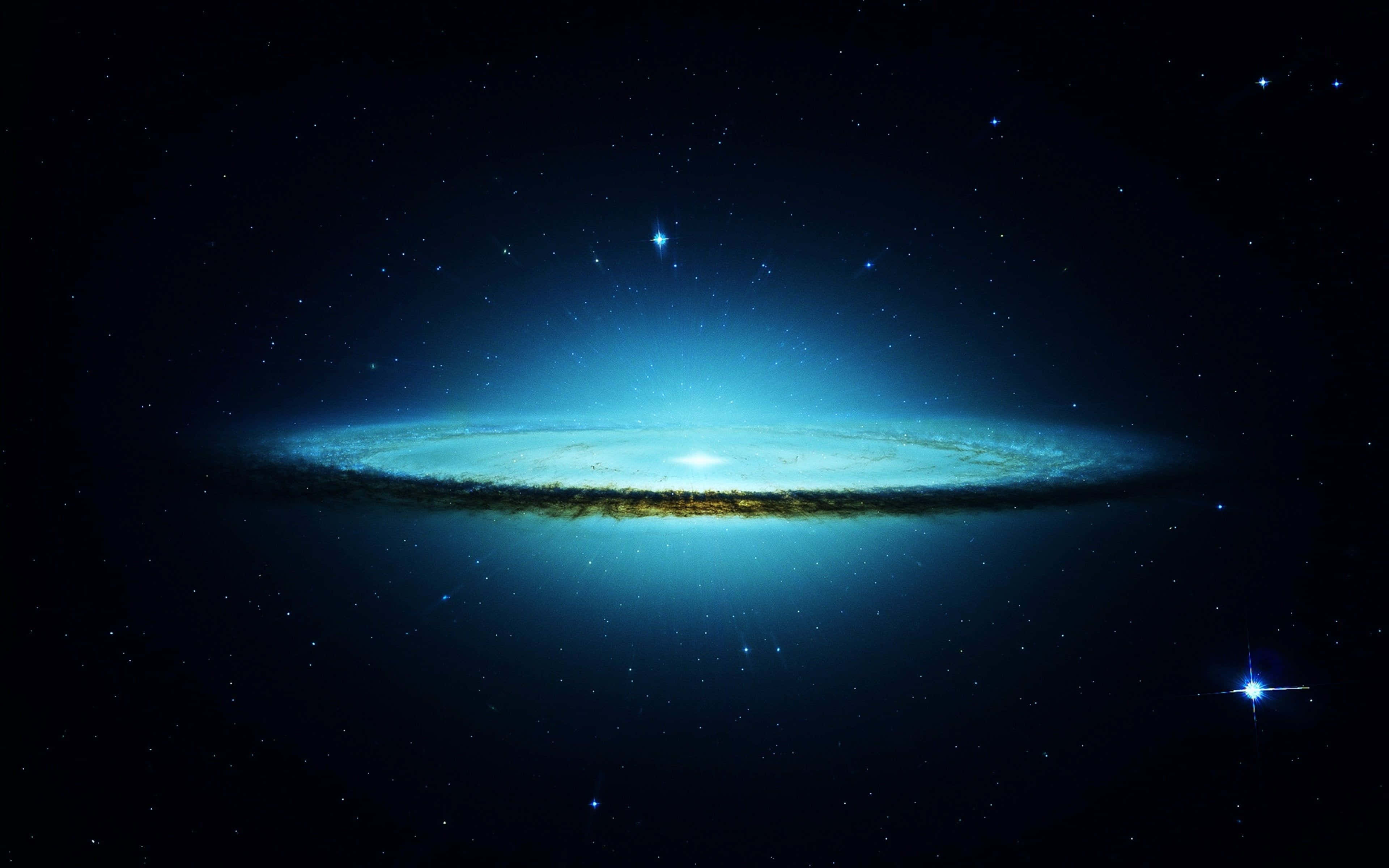 galaxies 桌布 壁紙 — 一個明亮的螺旋星系在繁星點點的宇宙虛空中閃耀著鮮豔的藍色和金色色調。