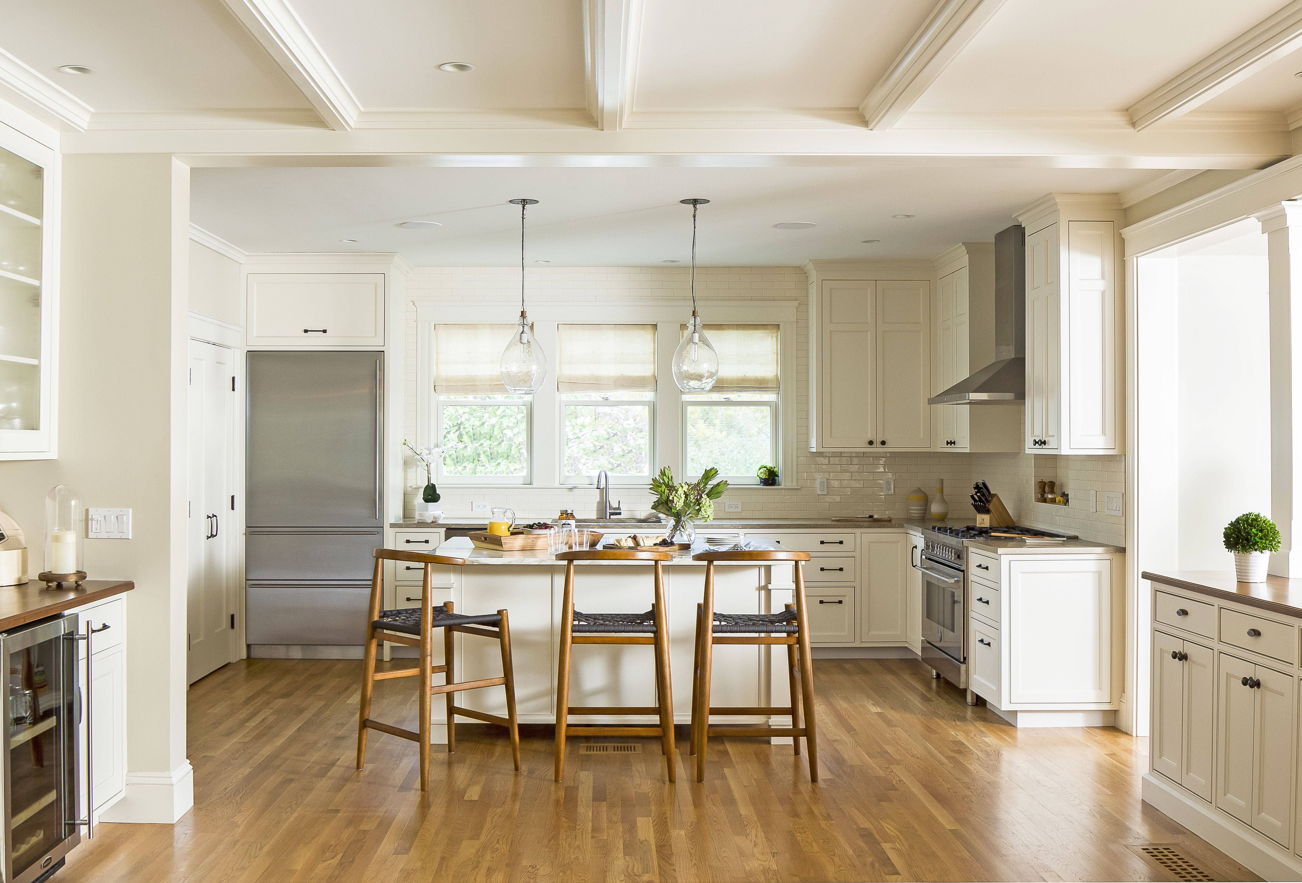 Kitchen Design 桌布 壁紙 — 一個明亮通風的廚房，配有白色櫥櫃、木地板和一個被大窗戶自然光照亮的中島。