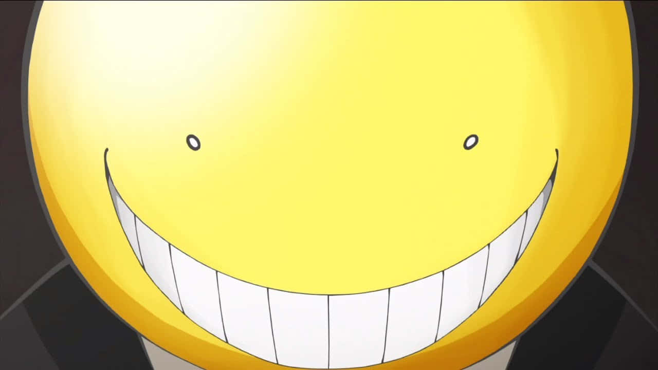 Koro Sensei 桌布 壁紙 — 一個明亮黃色動畫笑臉的特寫，露出寬闊的牙齒笑容和小小的黑色眼睛。