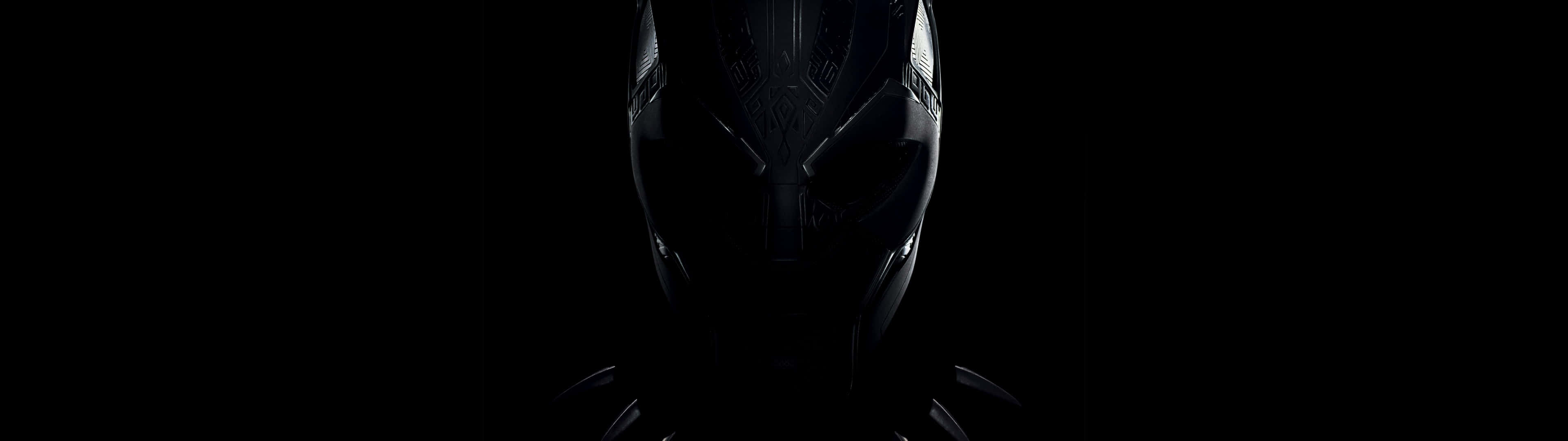 Marvel Black And White 桌布 壁紙 — 一個昏暗照明的黑豹面具在漆黑背景上微微發光。