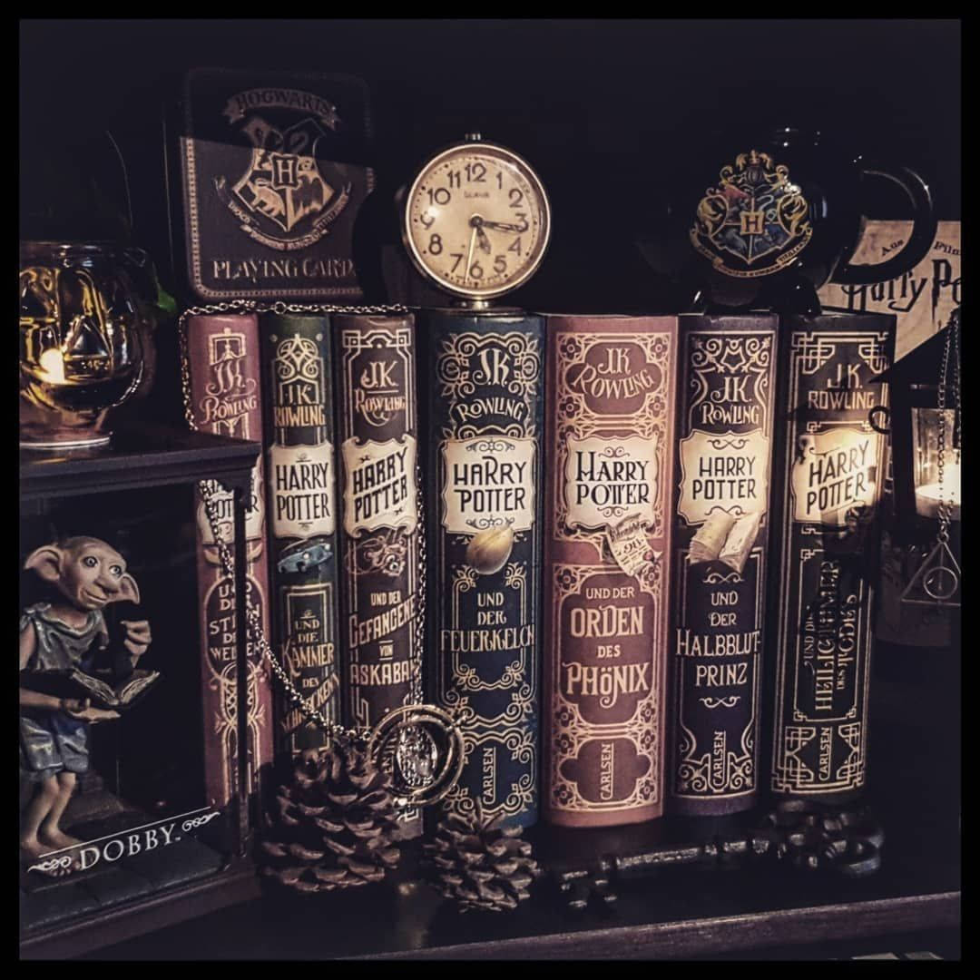 美學哈利波特 桌布 壁紙 — 一個昏暗的架子上展示著哈利波特書籍、一個時鐘、多比公仔和霍格華茲撲克牌。