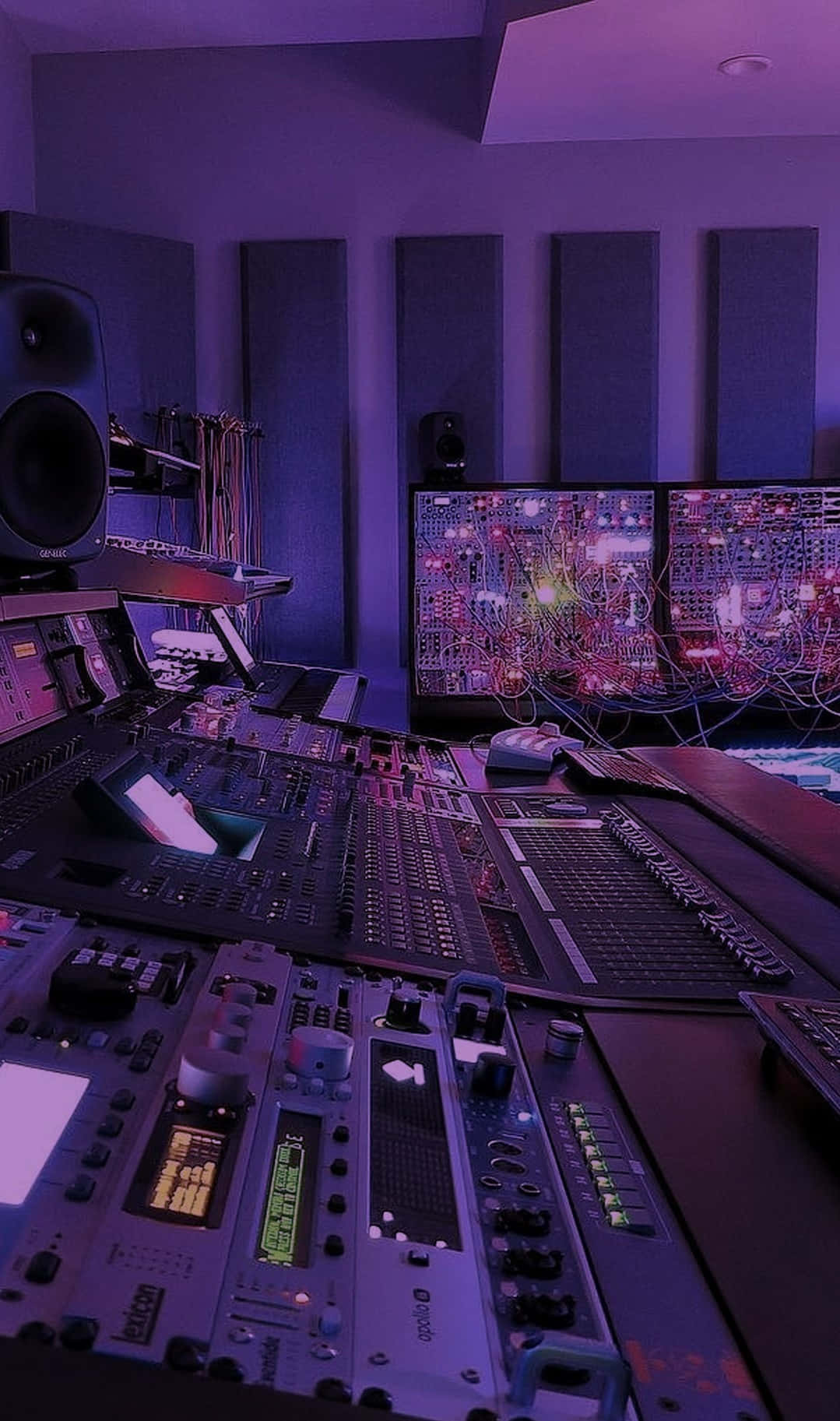 Fl Studio 桌布 壁紙 — 一個昏暗的音樂工作室沐浴在紫色燈光中，設有一個複雜的音頻混音台，周圍環繞著顯示彩色電路圖的顯示器和大尺寸的工作室揚聲器。