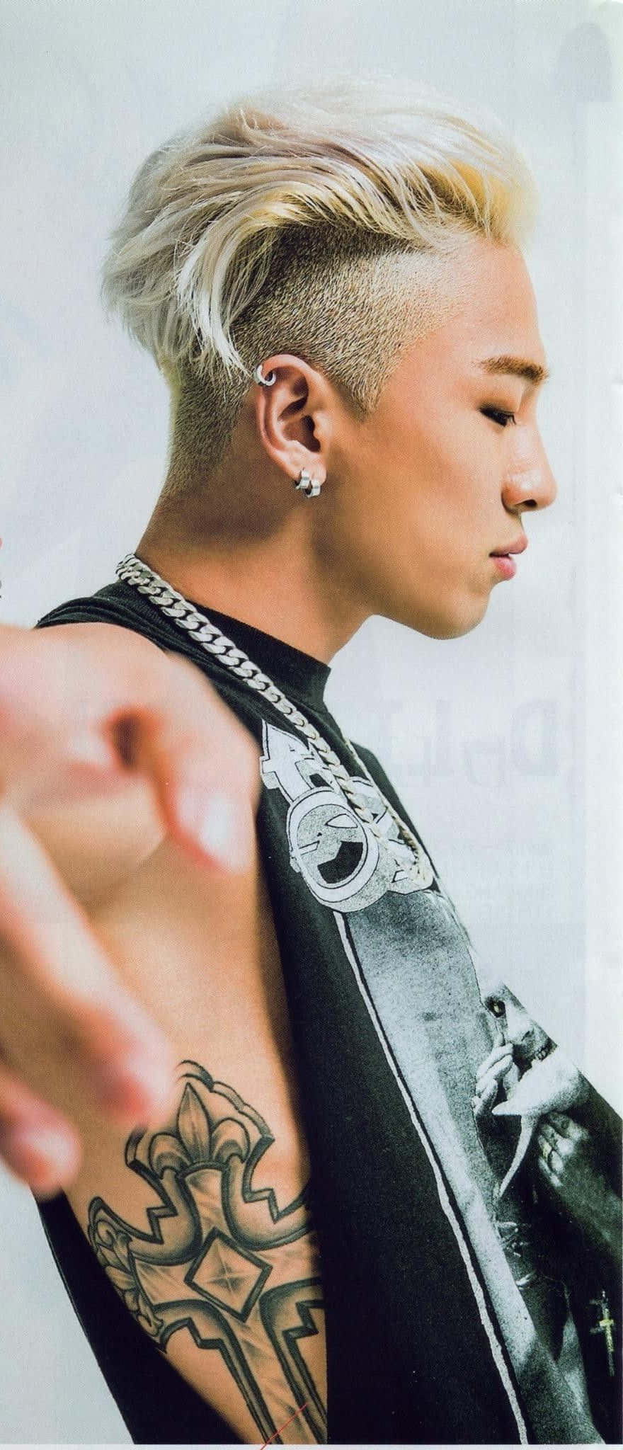 Bigbang 桌布 壁紙 — 一個時尚男士，擁有鉑金色頭髮和精細的手臂紋身，在純色背景前指向前面。