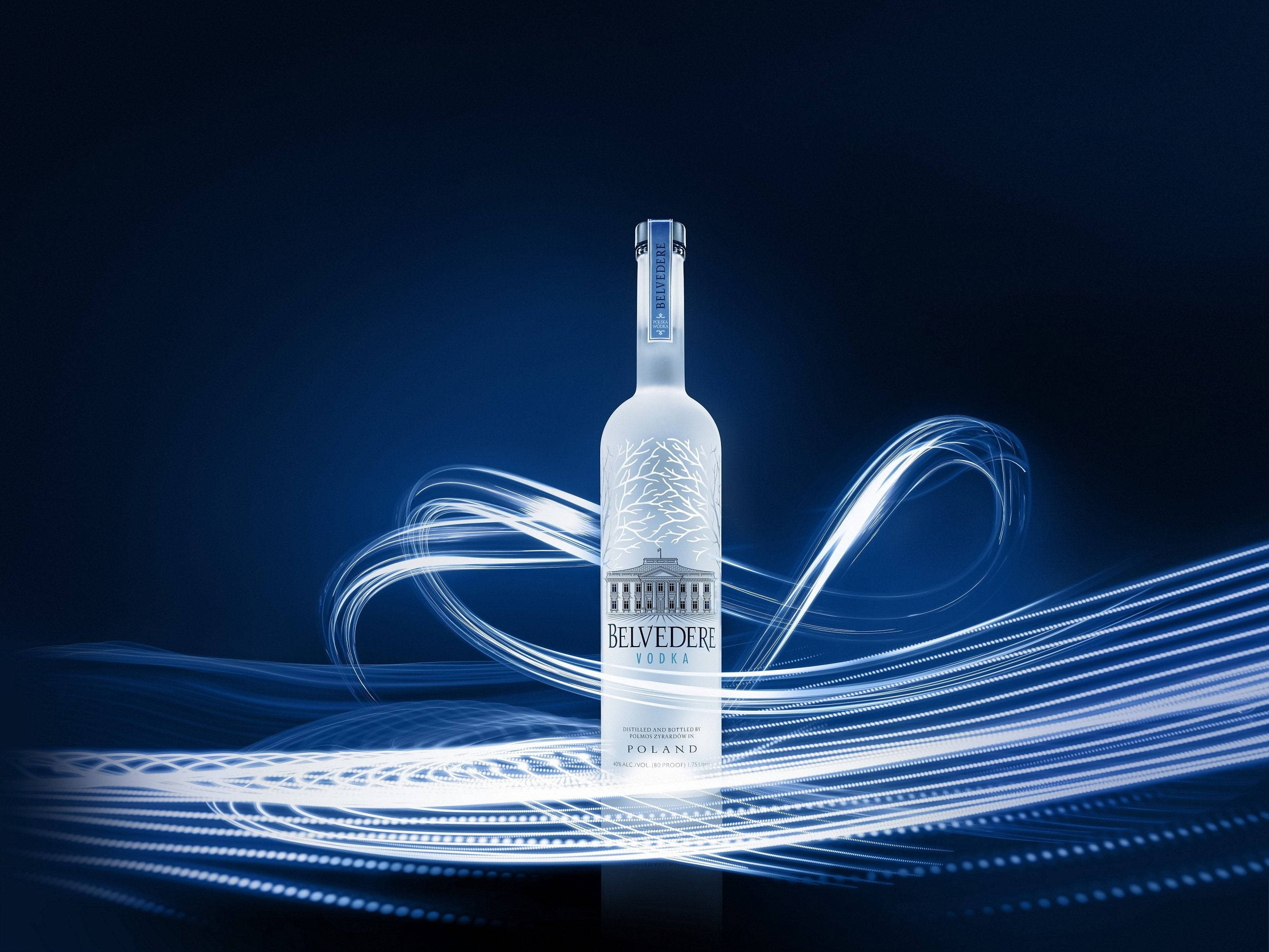 alcohol 桌布 壁紙 — 一個時尚的Belvedere伏特加酒瓶在深藍色背景下發光，動態的白色光線條紋在其周圍旋轉。