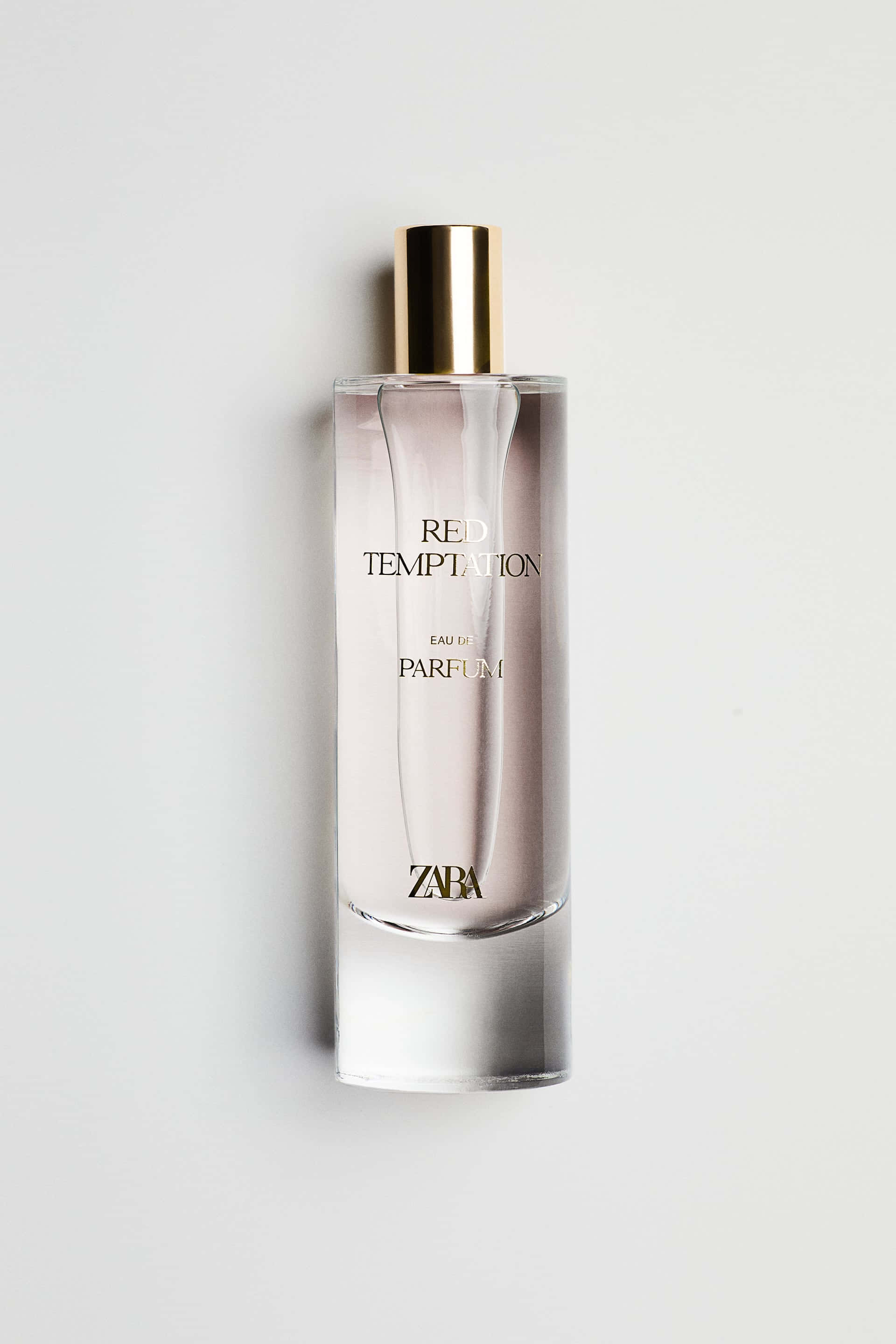 Zara 桌布 壁紙 — 一個時尚的Zara香水瓶，金色瓶蓋和玫瑰色液體，置於簡約白色背景中央。