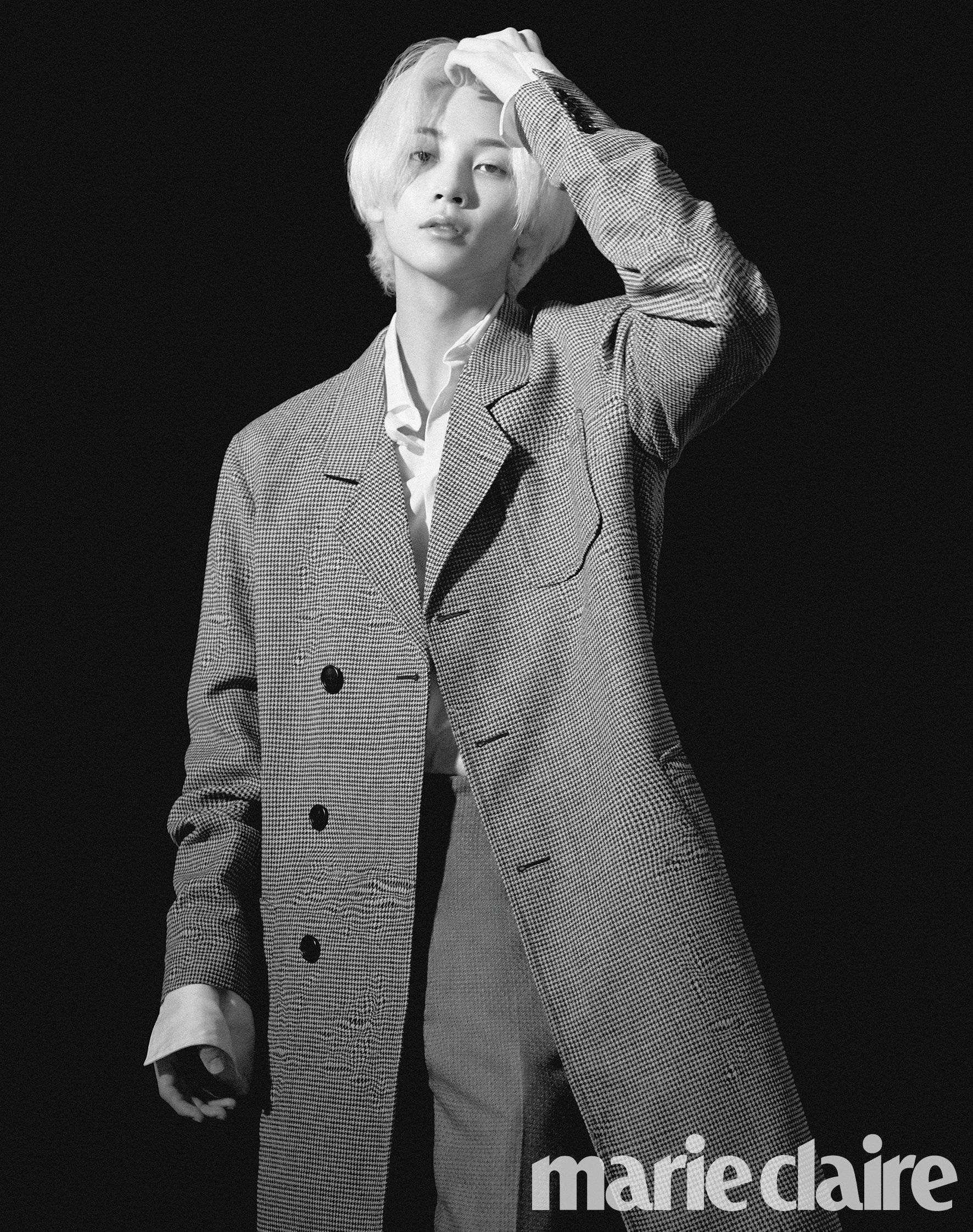 yoon jeonghan 桌布 壁紙 — 一個時尚的人，擁有一頭鉑金色頭髮，穿著格子大衣在黑色背景前擺姿勢。