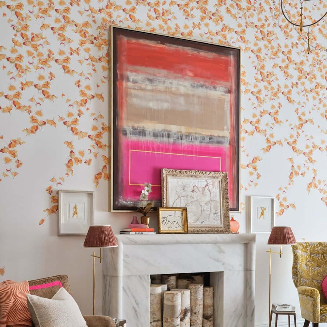 Autumn Fireplace 桌布 壁紙 — 一個時尚的客廳設有大理石壁爐，裝飾著藝術品，兩側是圖案椅子，牆壁覆蓋著金色銀杏葉壁紙。
