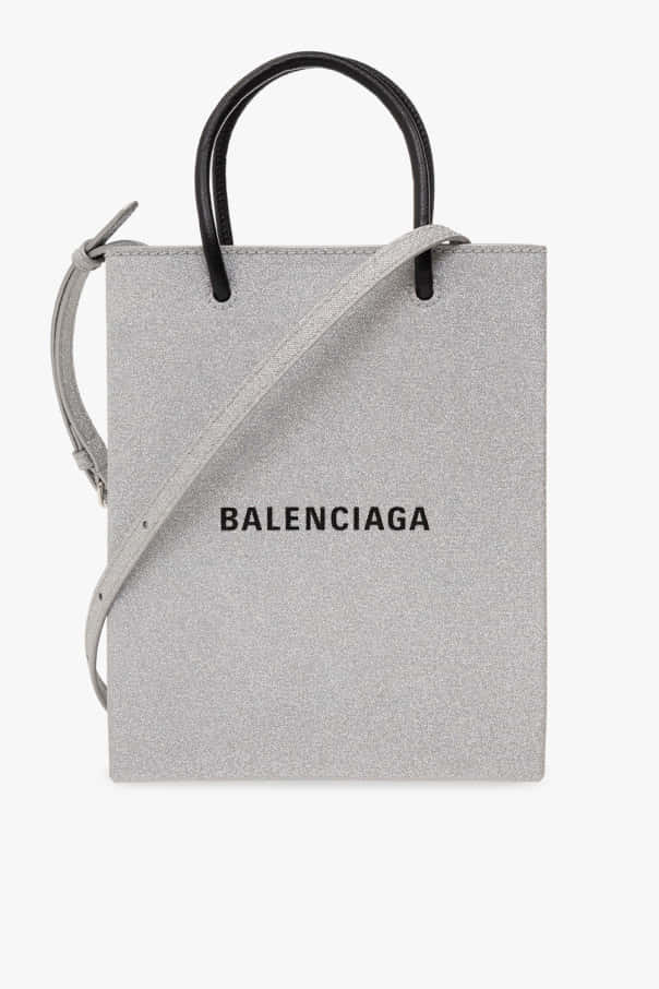 巴黎世家 桌布 壁紙 — 一個時尚的灰色Balenciaga手提袋，配有黑色手柄和肩帶，背景為純白色。