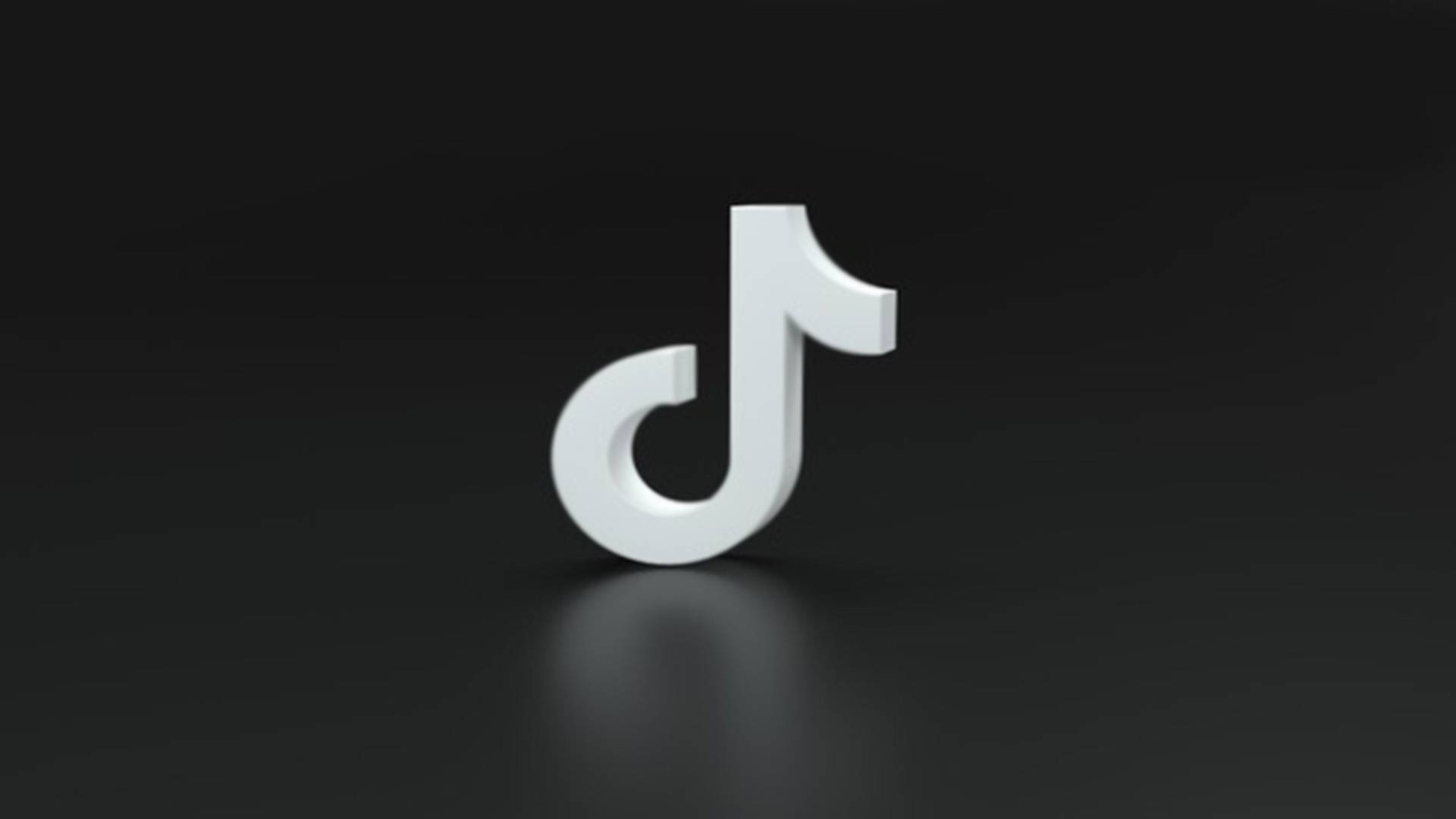 TikTok 動圖 桌布 壁紙 — 一個時尚的白色3D TikTok標誌位於黑暗反光表面中央，光線柔和。