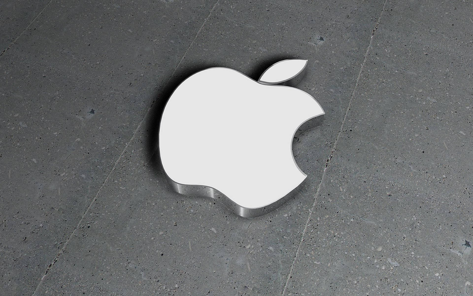 蘋果 桌布 壁紙 — 一個時尚的白色Apple標誌放置在帶有柔和陰影的紋理灰色混凝土地板上。