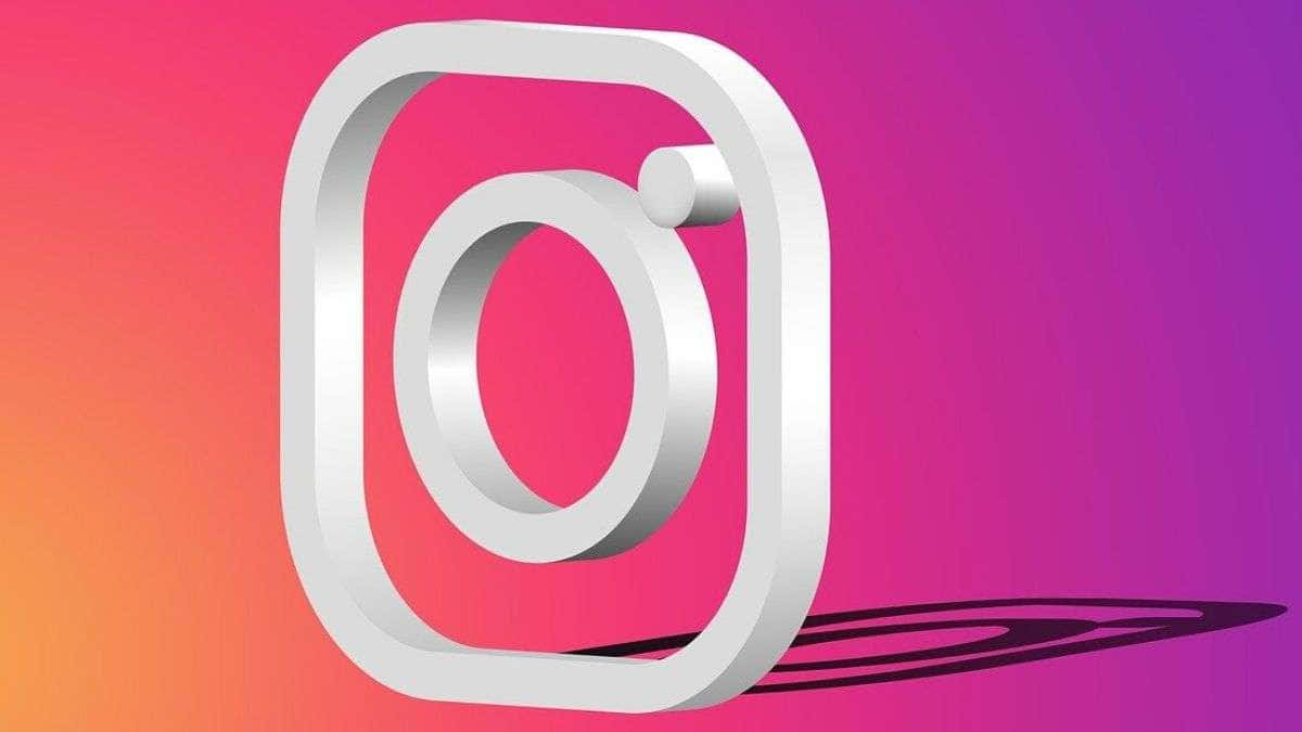 Instagram 桌布 壁紙 — 一個時尚的白色Instagram標誌在粉紅、橙色和紫色的鮮豔漸變背景上投下陰影。