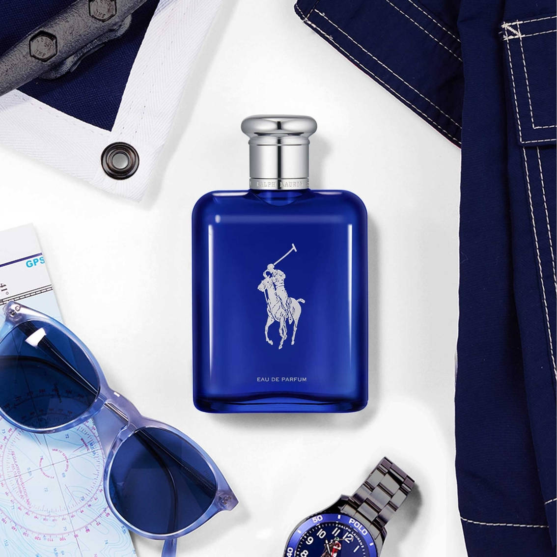 品牌 桌布 壁紙 — 一個時尚的藍色Ralph Lauren polo香水瓶，置中於海軍藍衣物、太陽眼鏡和手錶之間，放在白色表面上。