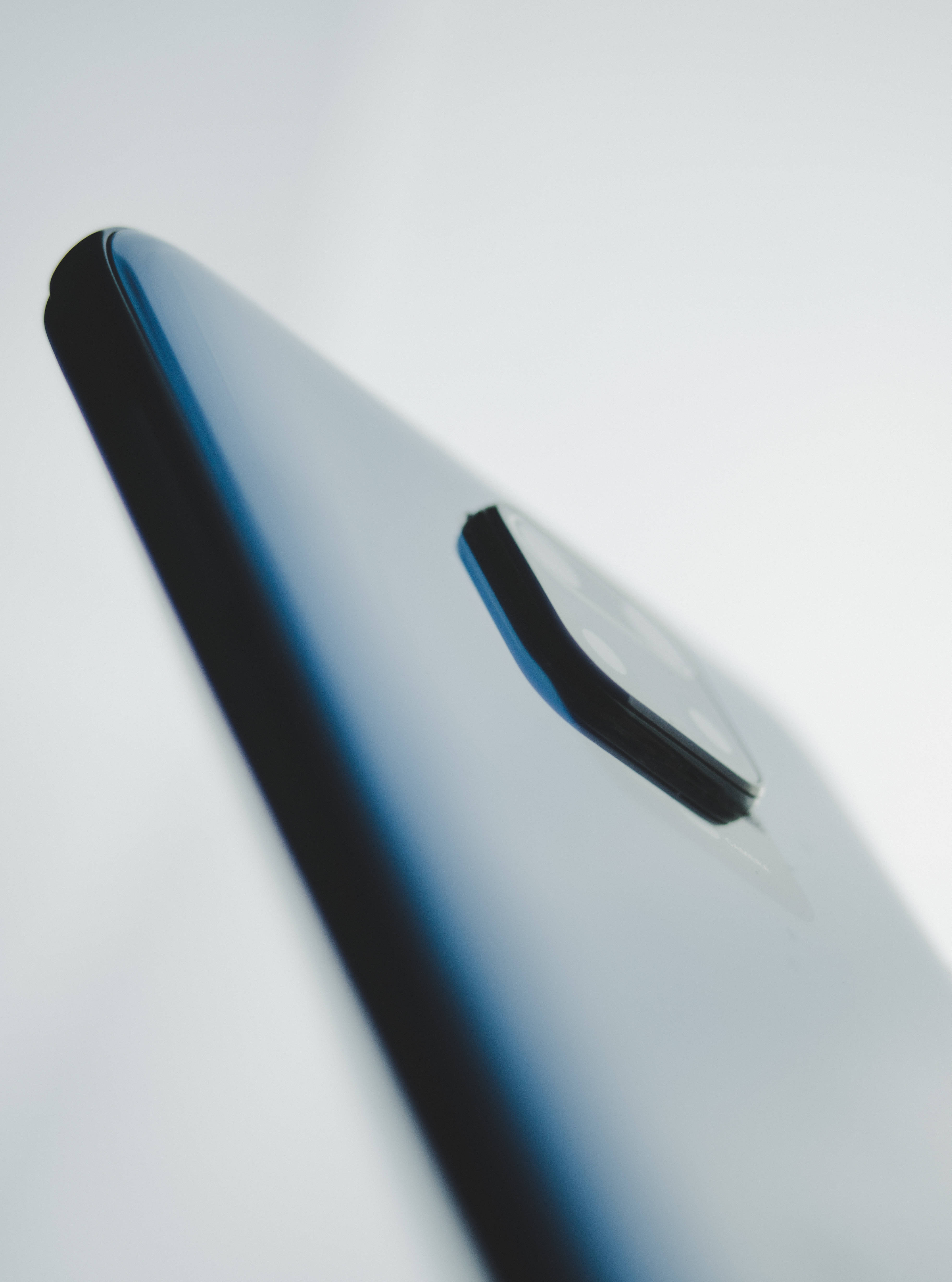 Xiaomi 桌布 壁紙 — 一個時尚的藍色智慧型手機角落，帶有黑色相機模組，置於柔和的白色背景上。