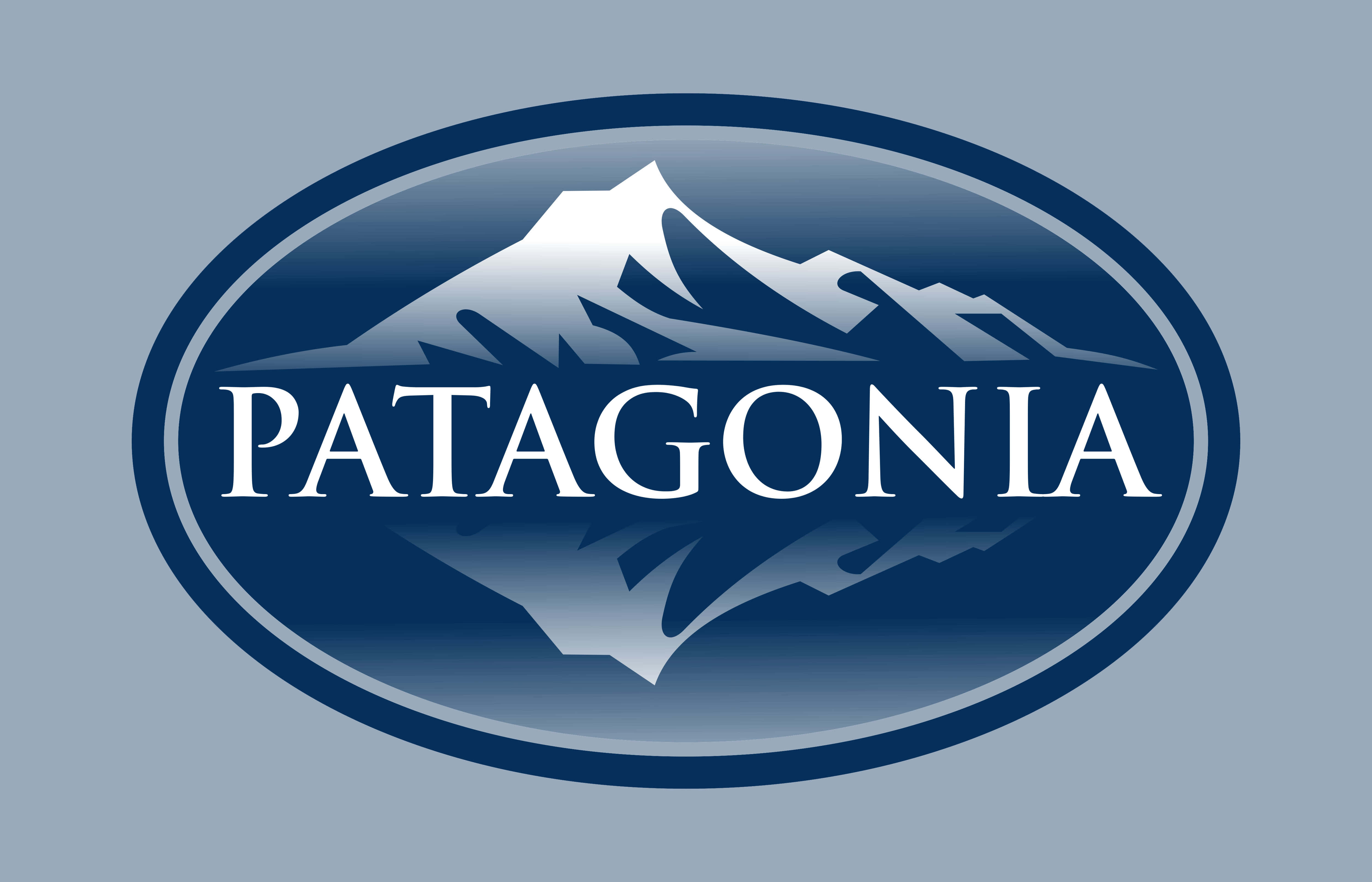 Patagonia 桌布 壁紙 — 一個時尚的藍色橢圓形標誌，帶有白色山脈輪廓和粗體白色字母的 Patagonia 字樣。