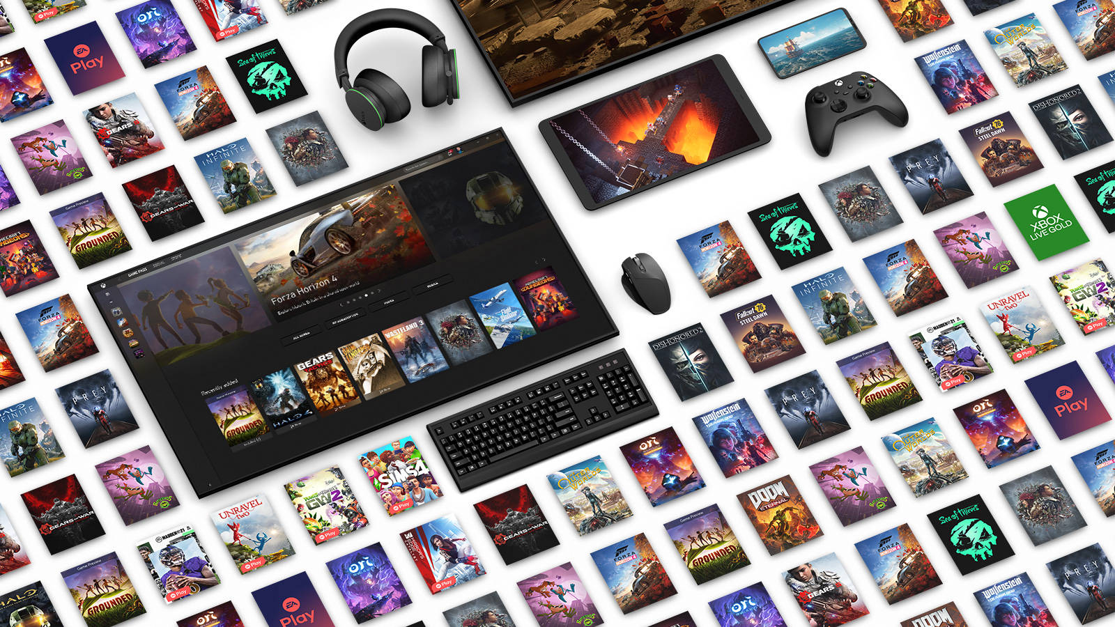 Xbox One X 桌布 壁紙 — 一個時尚的遊戲設置，配備顯示器、鍵盤、滑鼠、耳機和控制器，周圍環繞著色彩繽紛的遊戲封面，置於白色表面上。