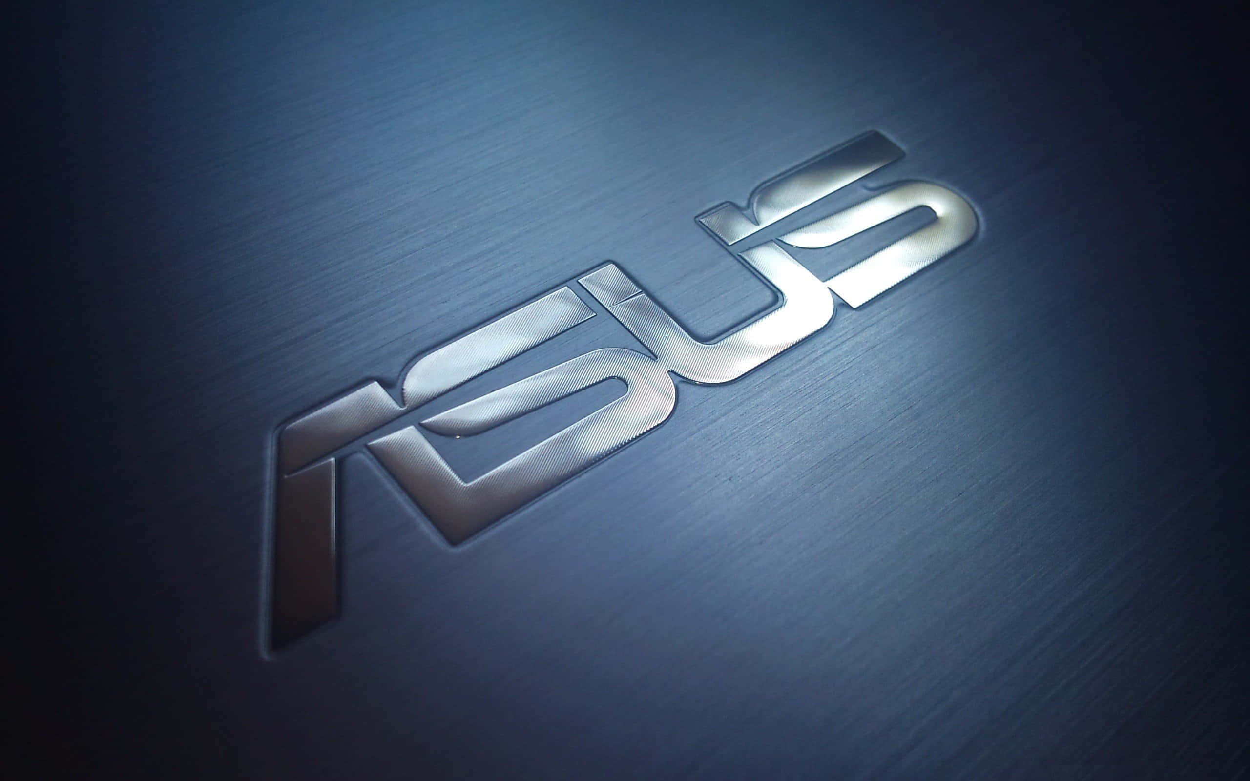 ASUS 桌布 壁紙 — 一個時尚的金屬ASUS標誌在聚焦燈光下在拉絲藍色表面上閃耀。