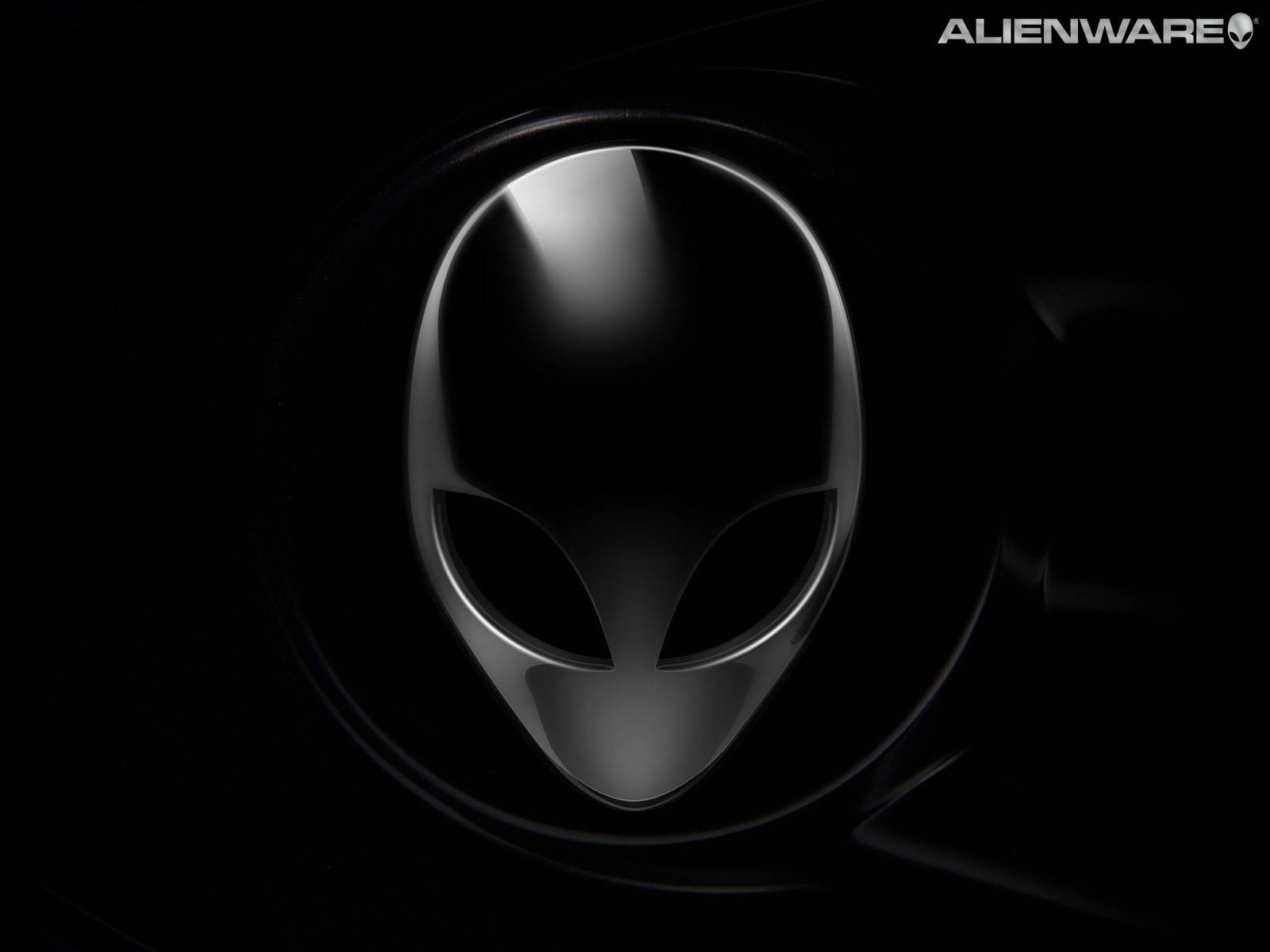 alienware default 桌布 壁紙 — 一個時尚的金屬外星人頭標誌在聚光燈下閃耀，背景為漆黑一片。